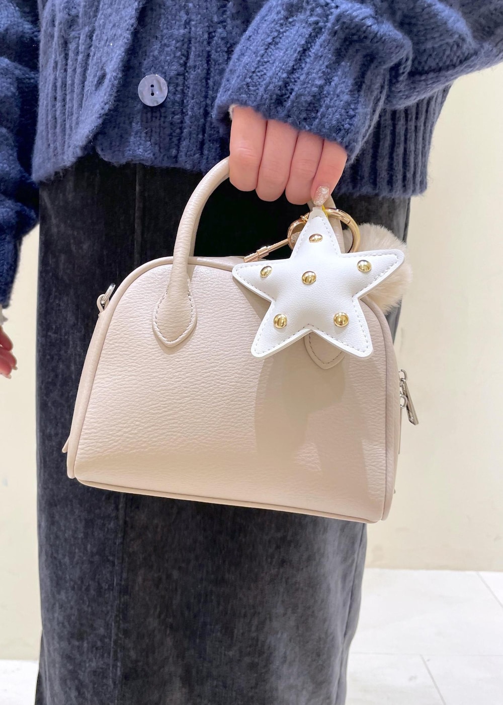 グレー系のスカート、ブルー系のカーディガン/ボレロ、ホワイト系のニット/セーターを着用したレディースの冬コーディネートの9枚目の写真