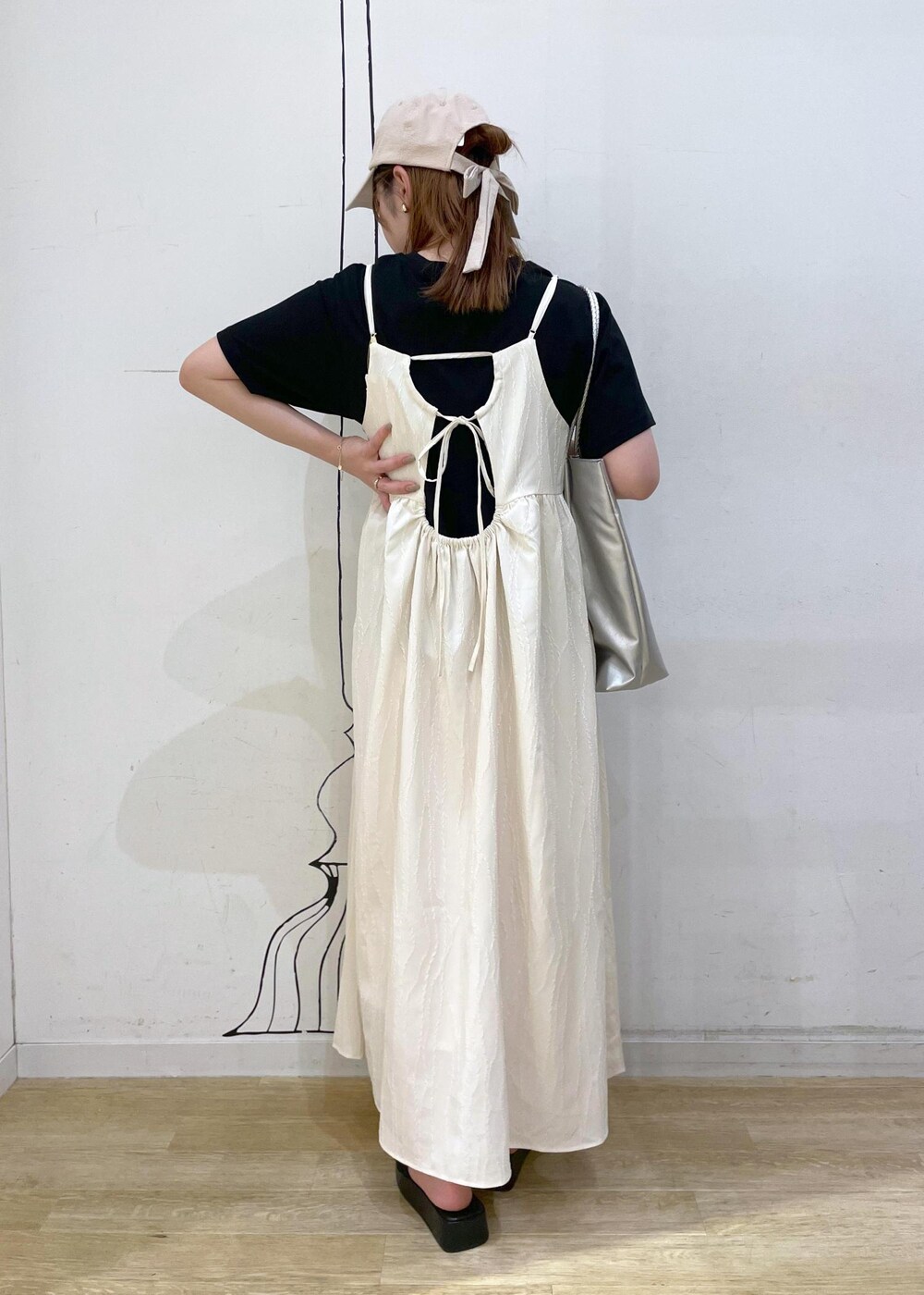 ブラック系のサンダル、ホワイト系のワンピース、ブラック系のTシャツ/カットソーを着用したレディースの夏コーディネートの2枚目の写真