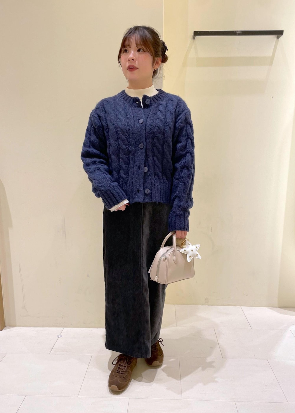 グレー系のスカート、ブルー系のカーディガン/ボレロ、ホワイト系のニット/セーターを着用したレディースの冬コーディネートの10枚目の写真