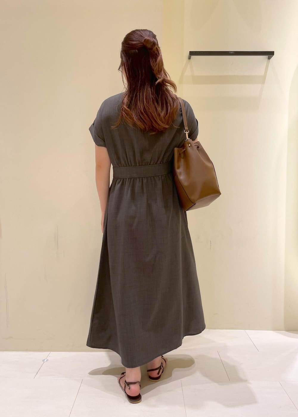 グレー系のワンピース、ブラウン系のサンダル、ブラウン系のショルダーバッグを着用したレディースの夏コーディネートの2枚目の写真