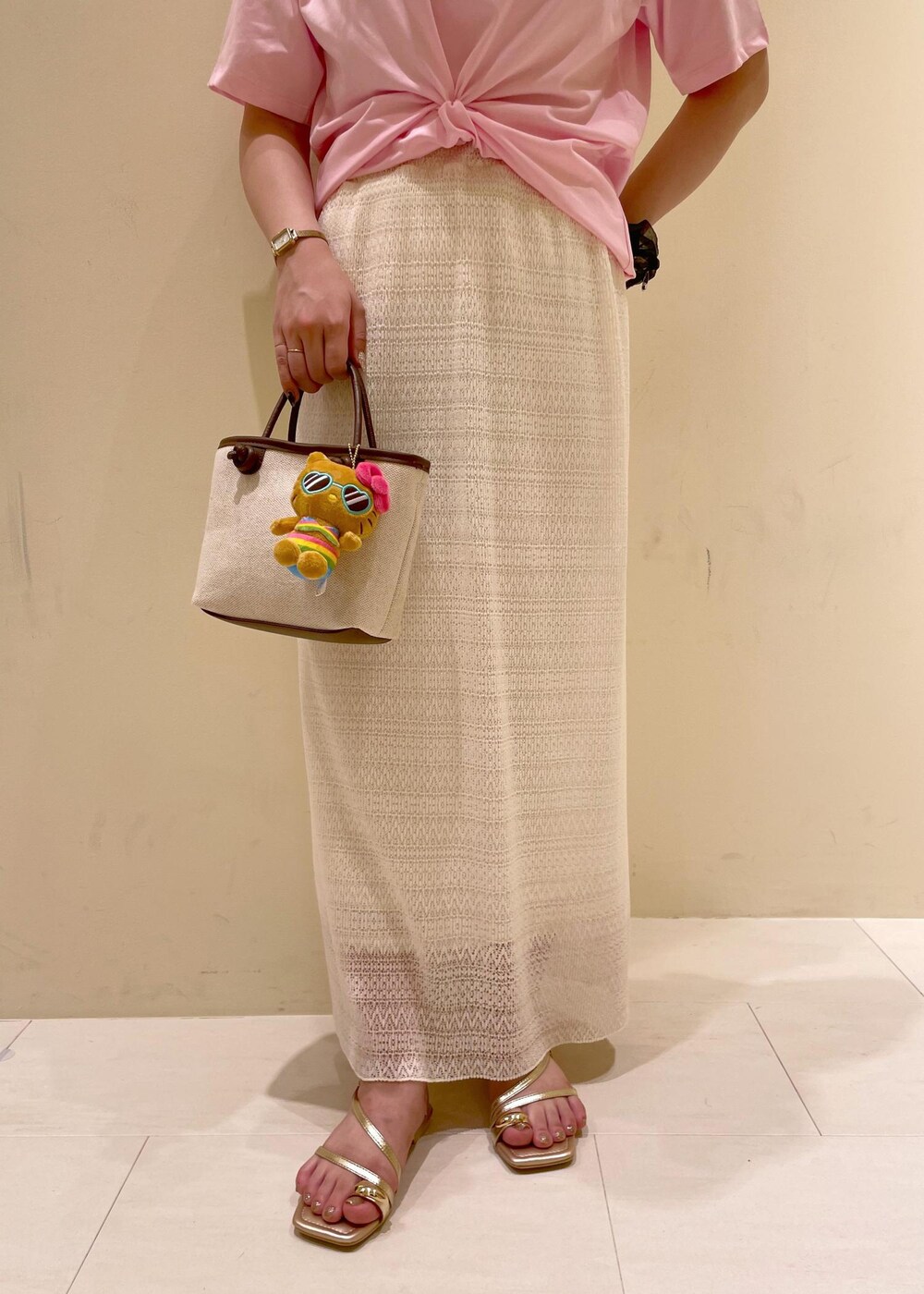 ホワイト系のスカート、ゴールド系のサンダル、ブラウン系のトートバッグを着用したレディースの夏コーディネートの8枚目の写真