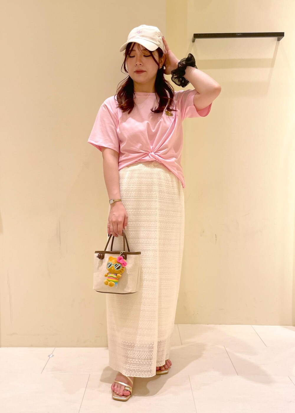 ホワイト系のスカート、ゴールド系のサンダル、ブラウン系のトートバッグを着用したレディースの夏コーディネートの6枚目の写真