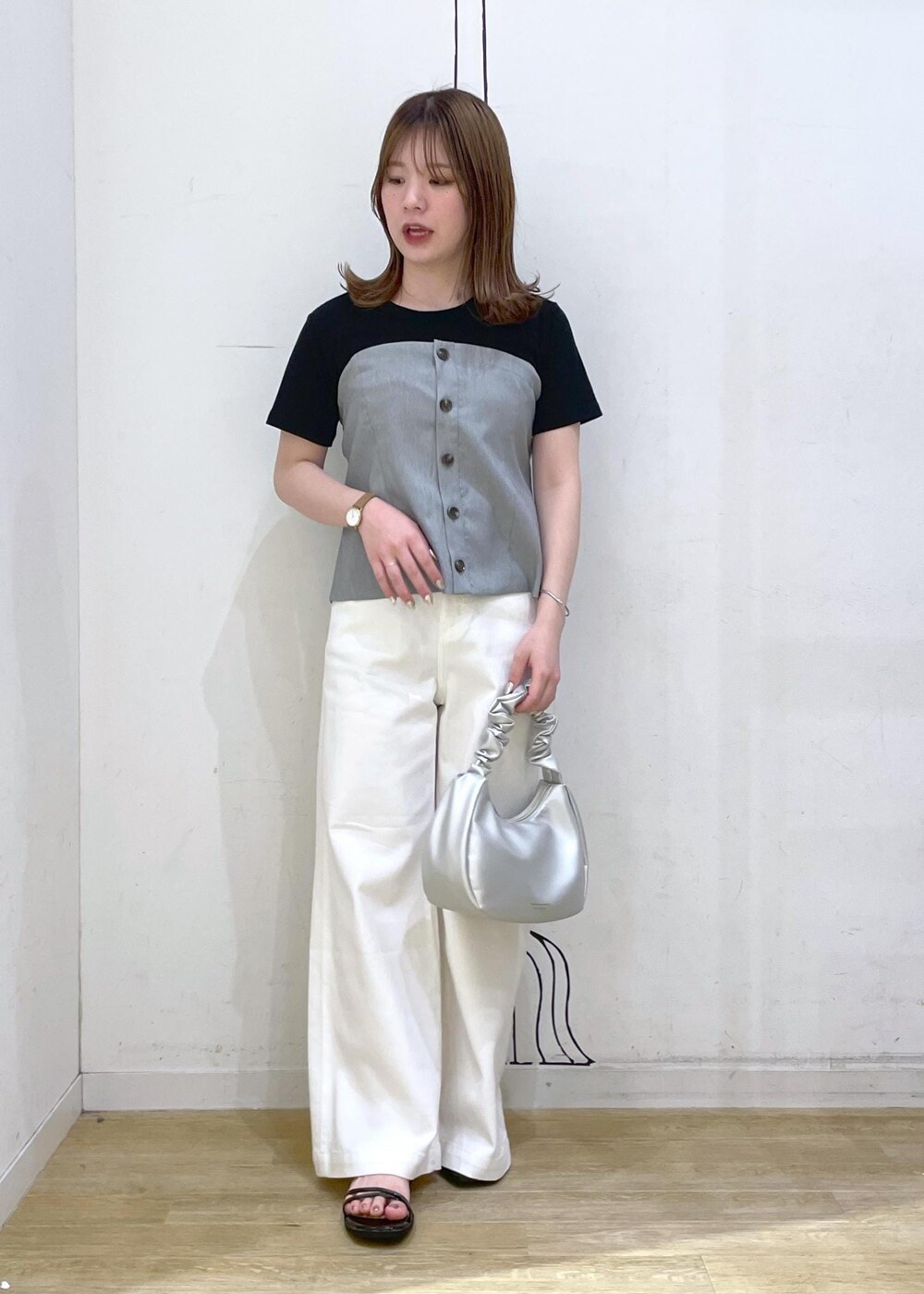 ブラック系のTシャツ/カットソー、ブラック系のサンダル、ホワイト系のデニムパンツを着用したレディースの春コーディネートの7枚目の写真