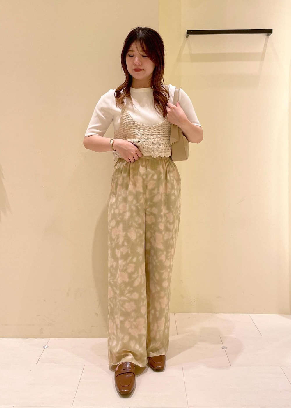 ベージュ系のハンドバッグ、ベージュ系のその他パンツ、イエロー系のローファーを着用したレディースの春コーディネートの4枚目の写真