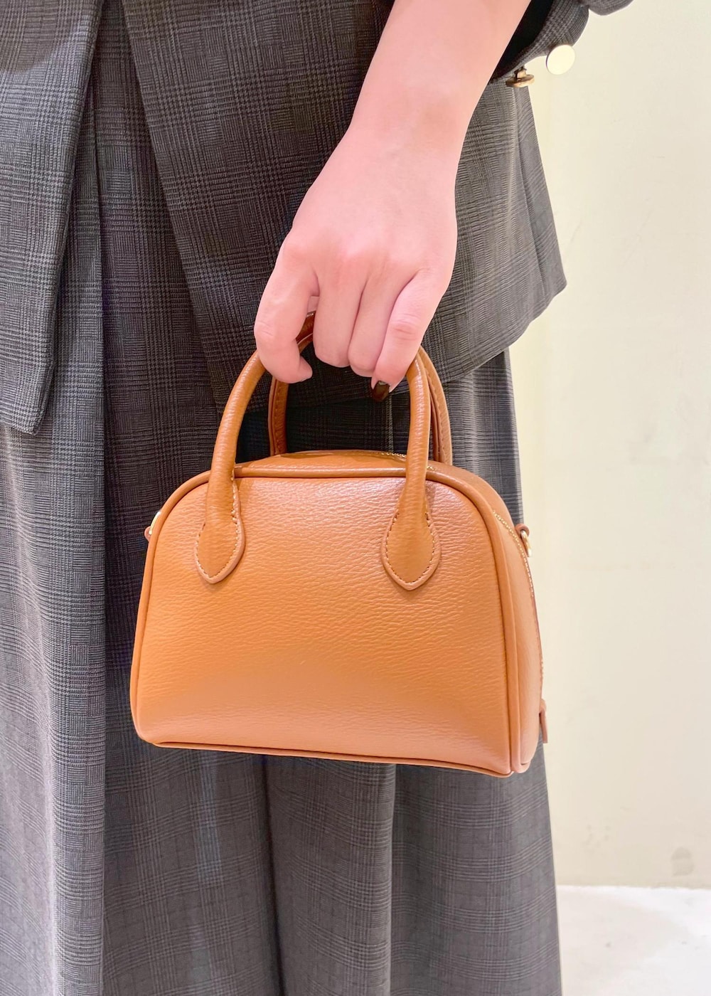 ブラック系のスカート、ブラック系のテーラードジャケット、ベージュ系のTシャツ/カットソーを着用したレディースの秋コーディネートの10枚目の写真