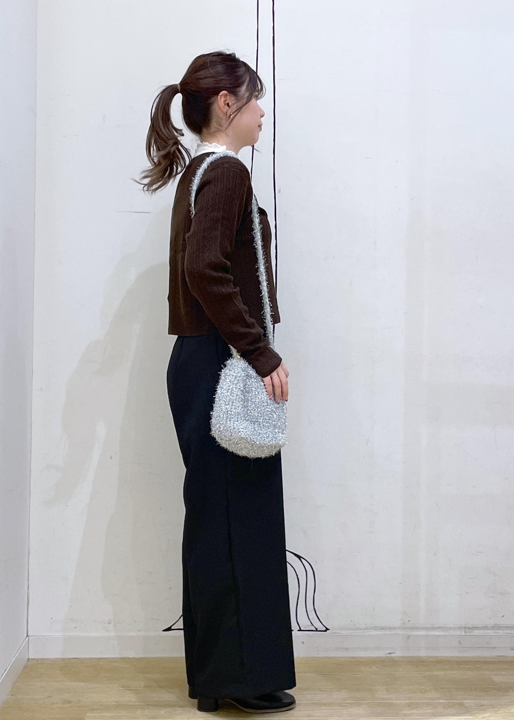 ホワイト系のTシャツ/カットソー、ブラック系のブーツ、ブラウン系のカーディガン/ボレロを着用したレディースの秋コーディネートの3枚目の写真