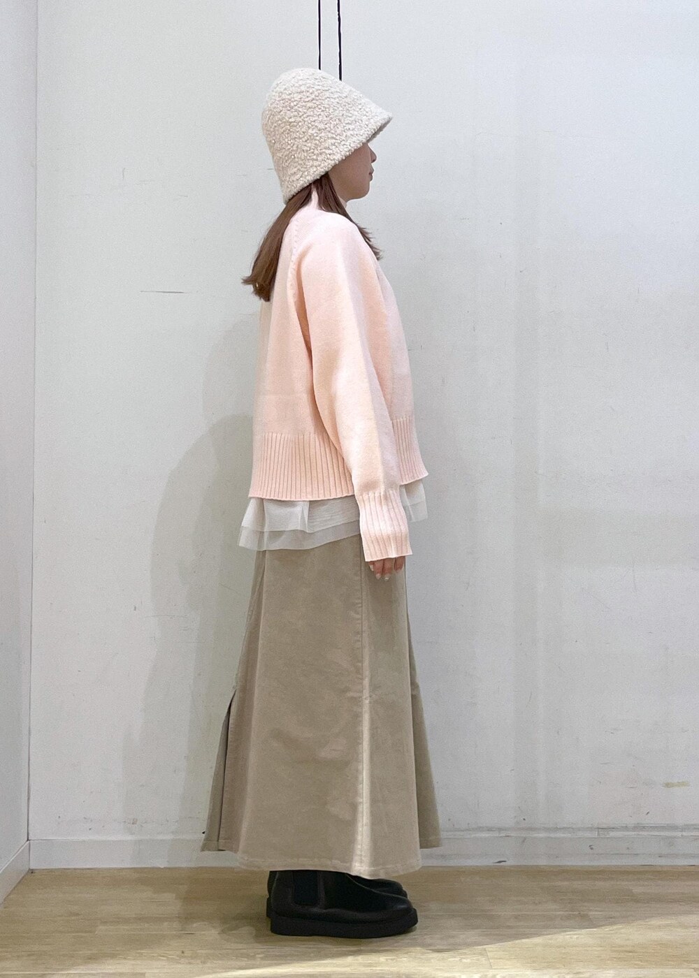 ピンク系のニット/セーター、ブラック系のブーツ、ブラック系のショルダーバッグを着用したレディースの冬コーディネートの3枚目の写真