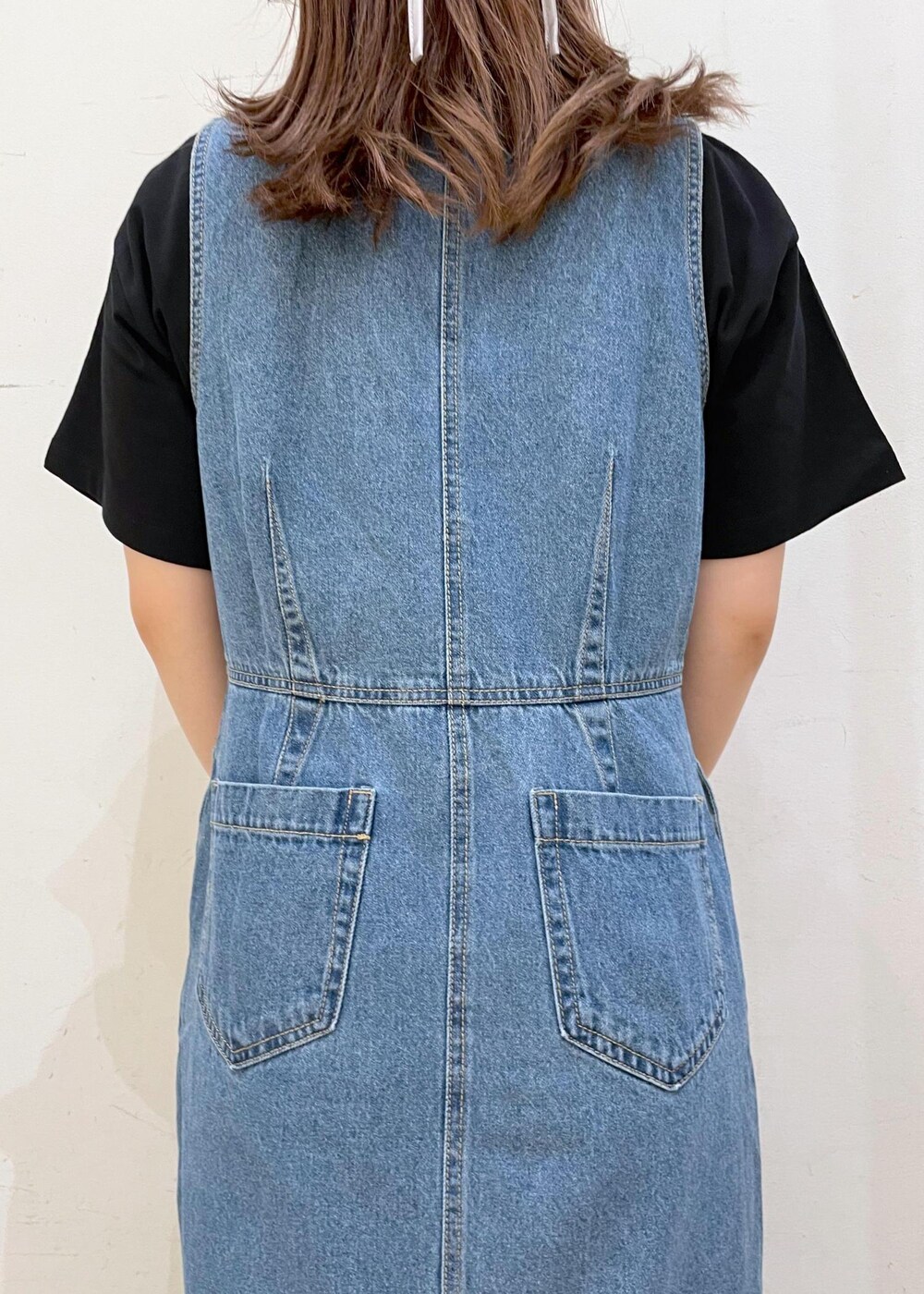 ホワイト系のスニーカー、ブラック系のハンドバッグ、ブルー系のジャンパースカートを着用したレディースの夏コーディネートの10枚目の写真