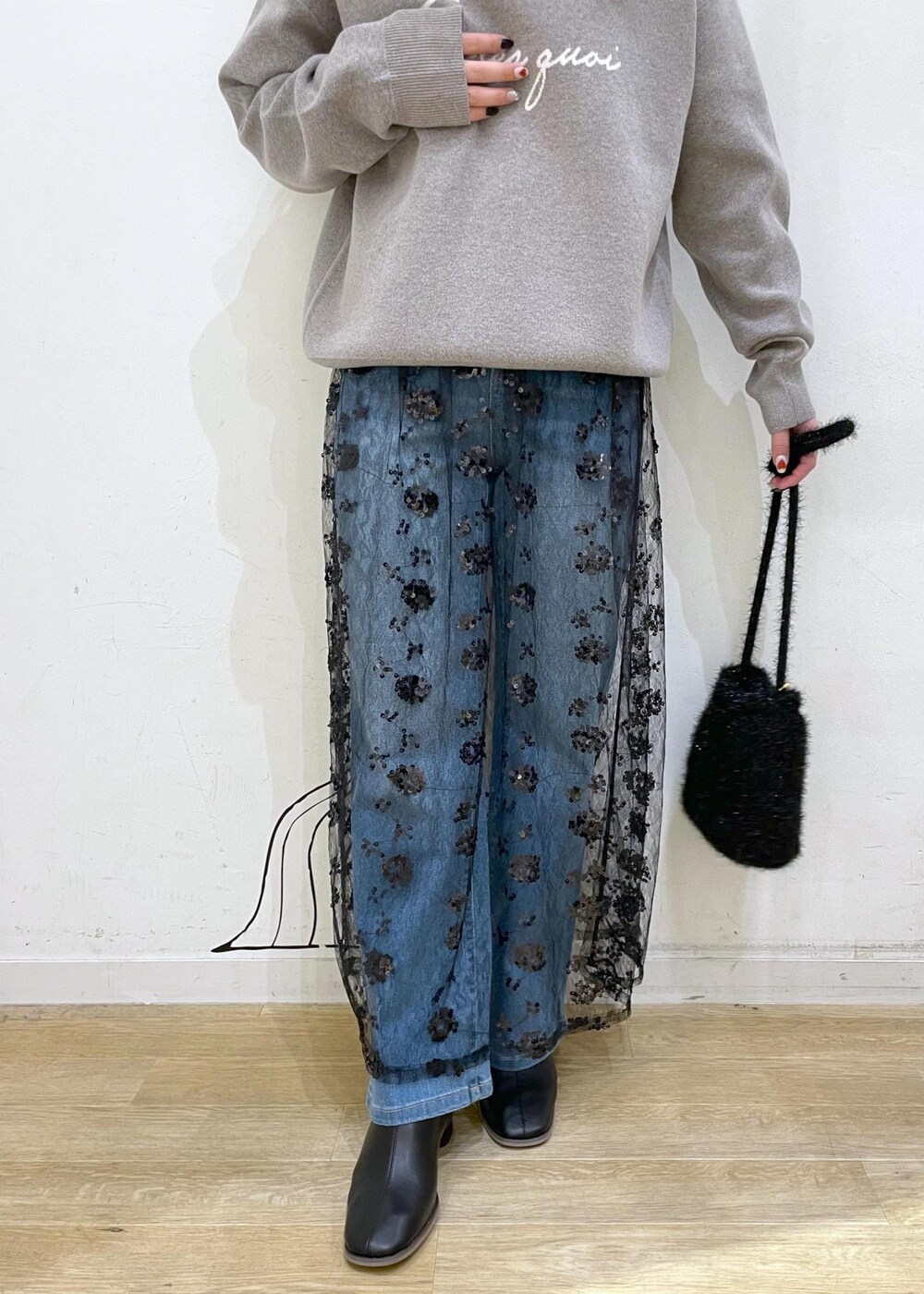 ブラック系のスカート、グレー系のニット/セーター、ブラック系のブーツを着用したレディースの秋コーディネートの6枚目の写真