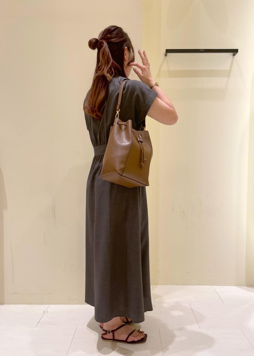 グレー系のワンピース、ブラウン系のサンダル、ブラウン系のショルダーバッグを着用したレディースの夏コーディネートの3枚目の写真
