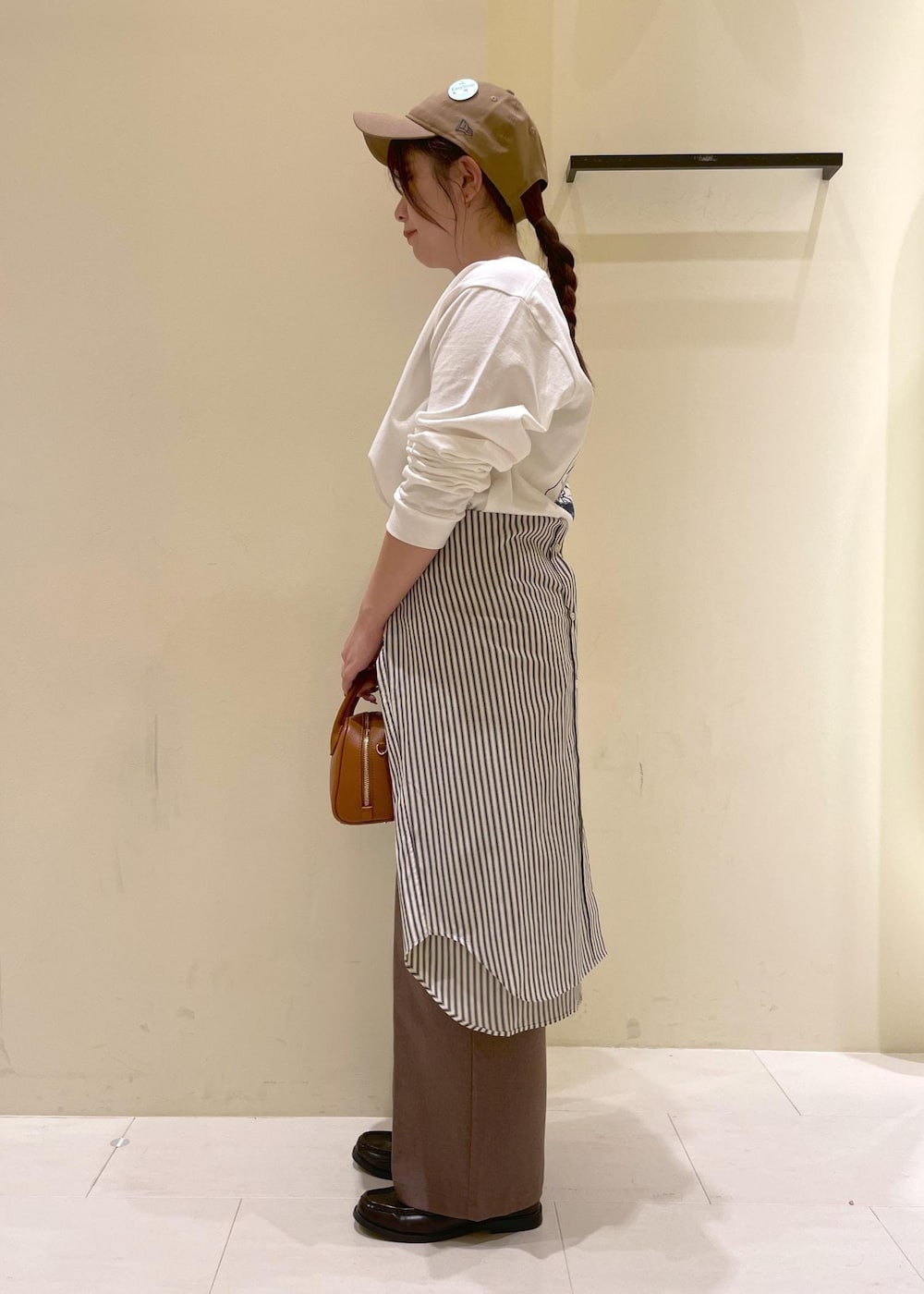 ホワイト系のシャツ/ブラウス、ホワイト系のTシャツ/カットソー、ベージュ系のスラックスを着用したレディースの秋コーディネートの4枚目の写真