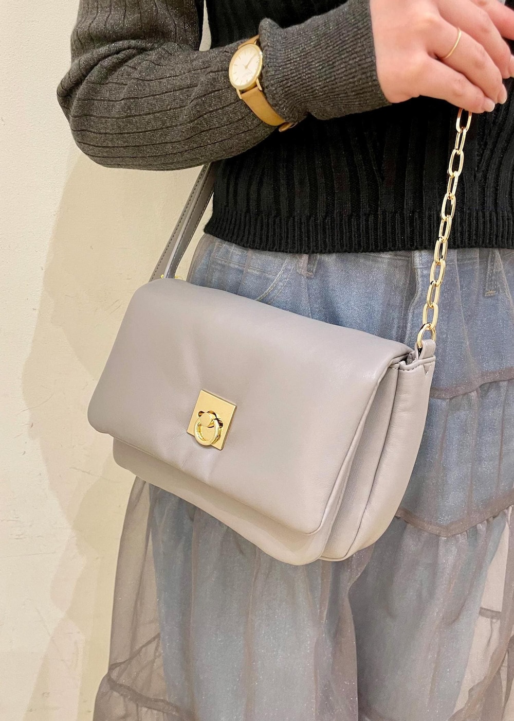 グレー系のショルダーバッグ、ブラック系のベスト、グレー系のニット/セーターを着用したレディースの春コーディネートの7枚目の写真