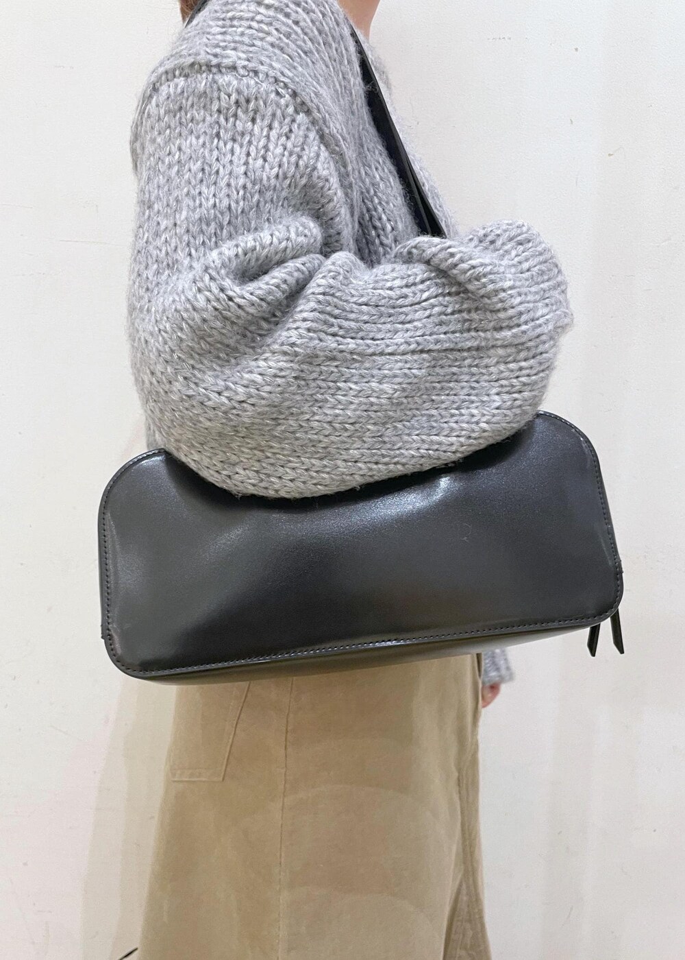 ホワイト系のTシャツ/カットソー、ブラック系のボストンバッグ、ベージュ系のスカートを着用したレディースの冬コーディネートの9枚目の写真