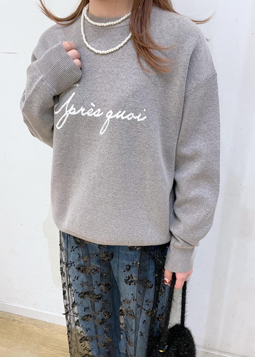 ブラック系のスカート、グレー系のニット/セーター、ブラック系のブーツを着用したレディースの秋コーディネートの5枚目の写真