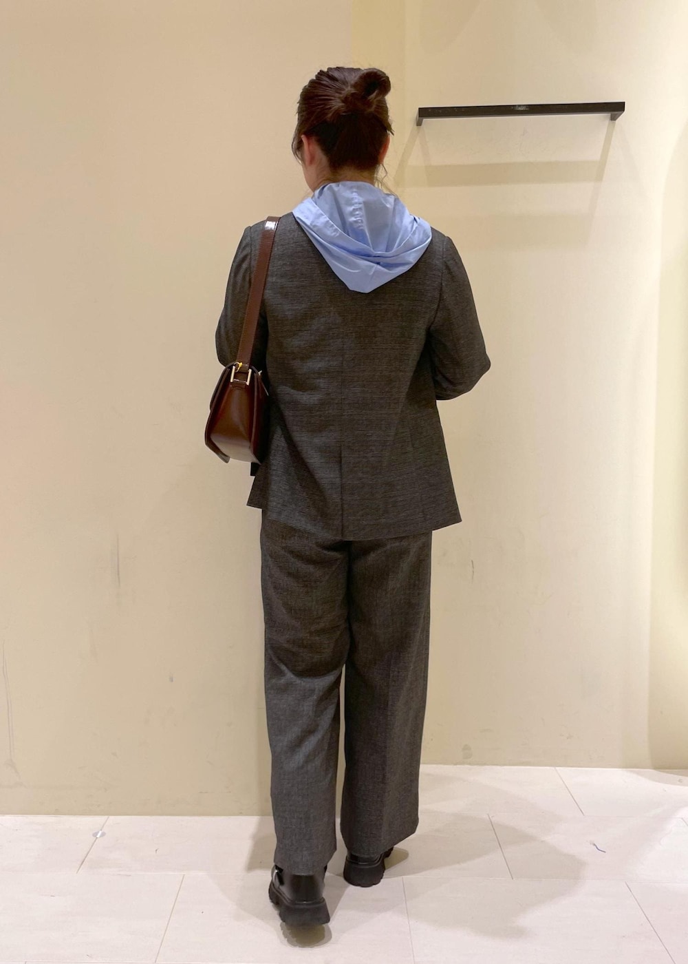 レッド系のショルダーバッグ、グレー系のテーラードジャケット、グレー系のスラックスを着用したレディースの秋コーディネートの3枚目の写真