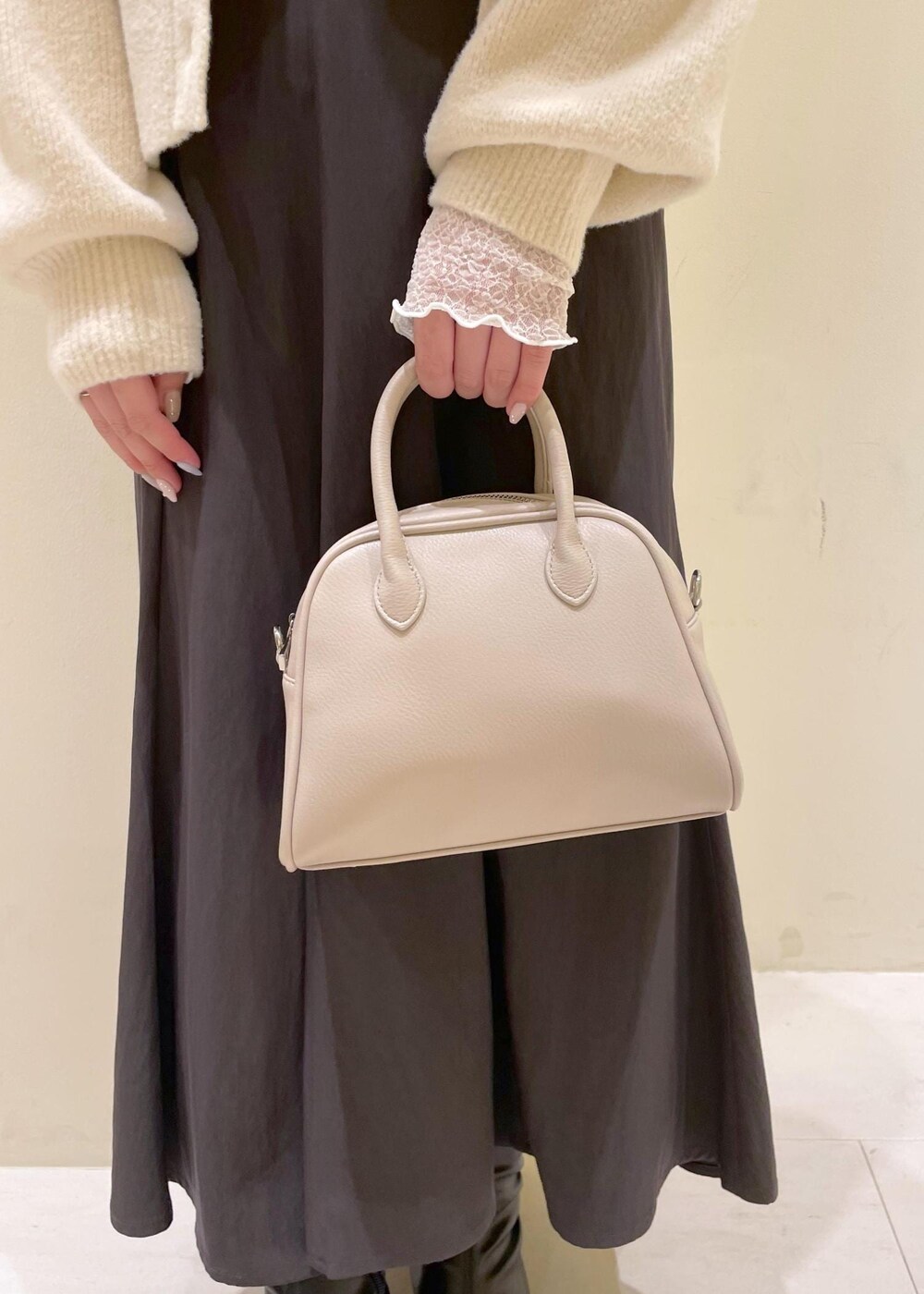 グレー系のスカート、ホワイト系のカーディガン/ボレロ、ホワイト系のTシャツ/カットソーを着用したレディースの秋コーディネートの8枚目の写真