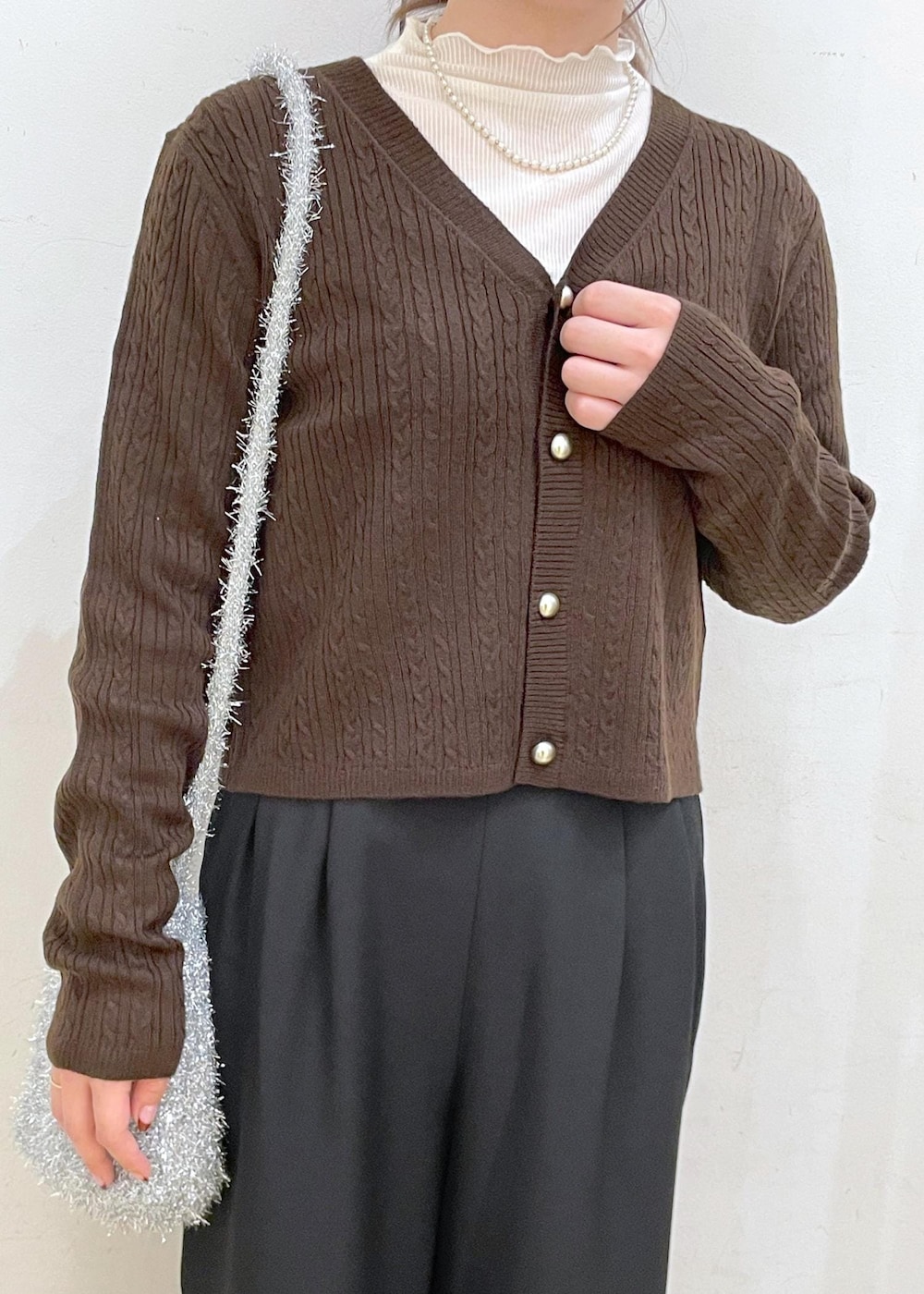 ホワイト系のTシャツ/カットソー、ブラック系のブーツ、ブラウン系のカーディガン/ボレロを着用したレディースの秋コーディネートの5枚目の写真