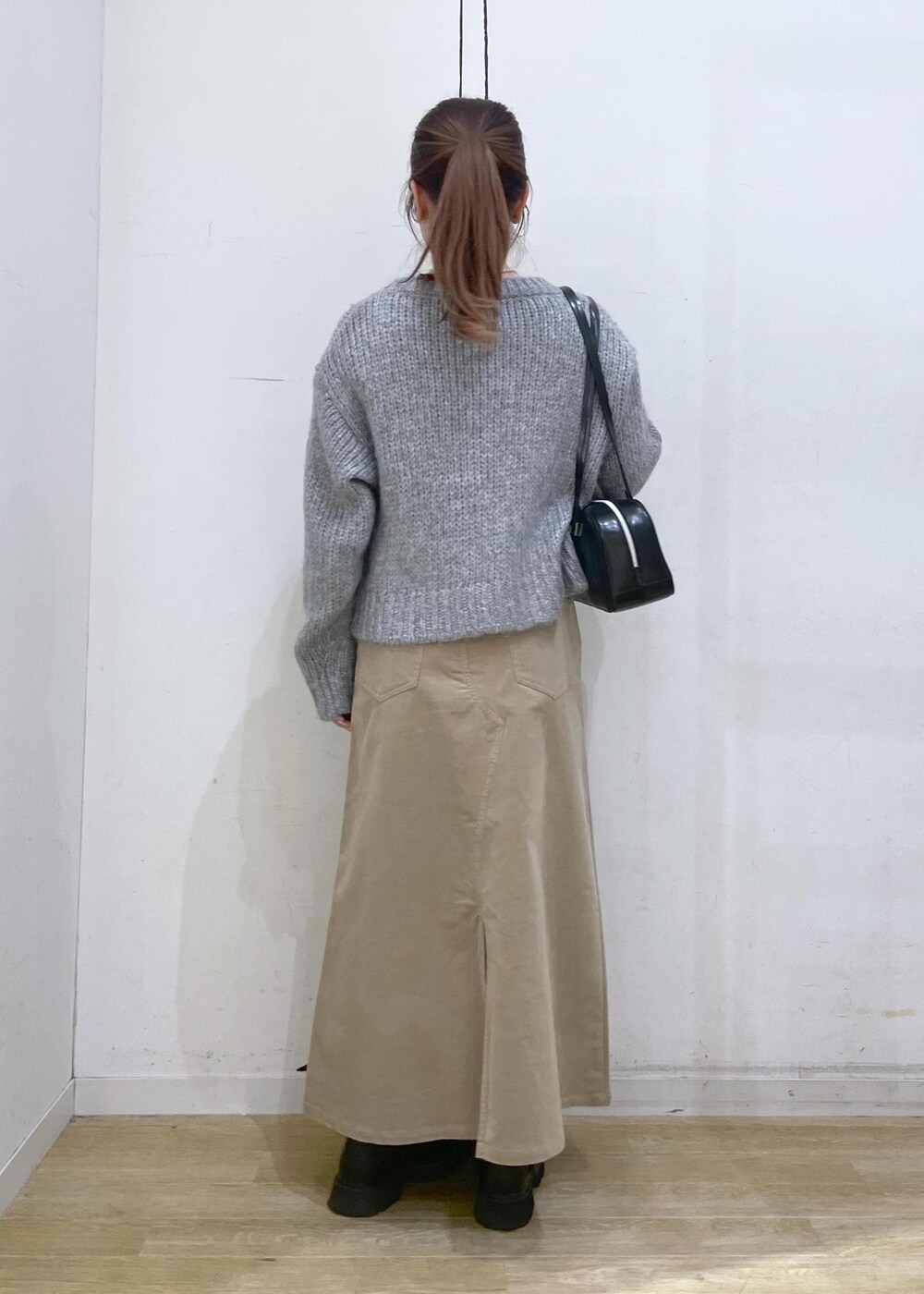 ホワイト系のTシャツ/カットソー、ブラック系のボストンバッグ、ベージュ系のスカートを着用したレディースの冬コーディネートの2枚目の写真