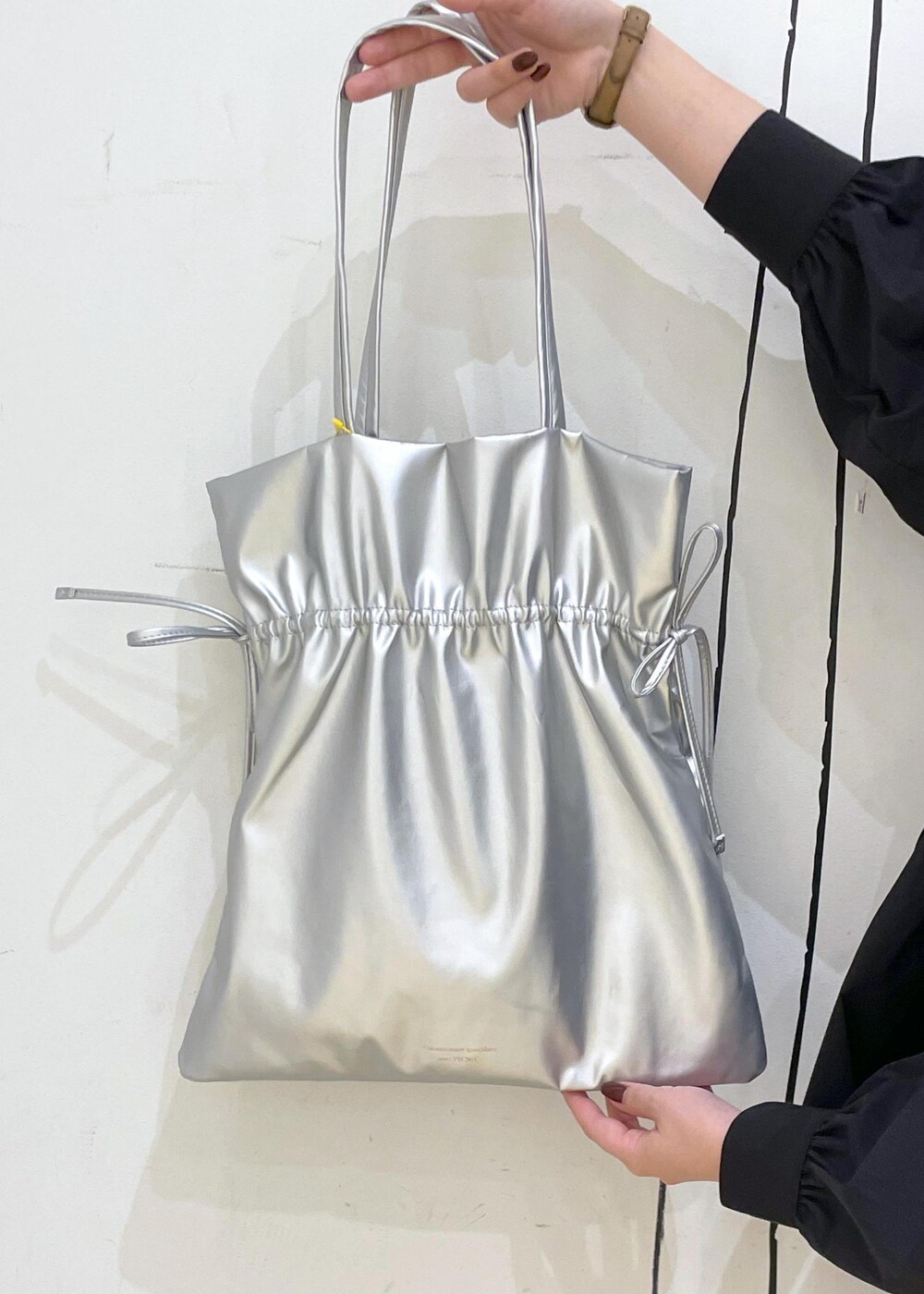 ブラック系のパンプス、シルバー系のトートバッグ、ブラック系のシャツ/ブラウスを着用したレディースの秋コーディネートの6枚目の写真