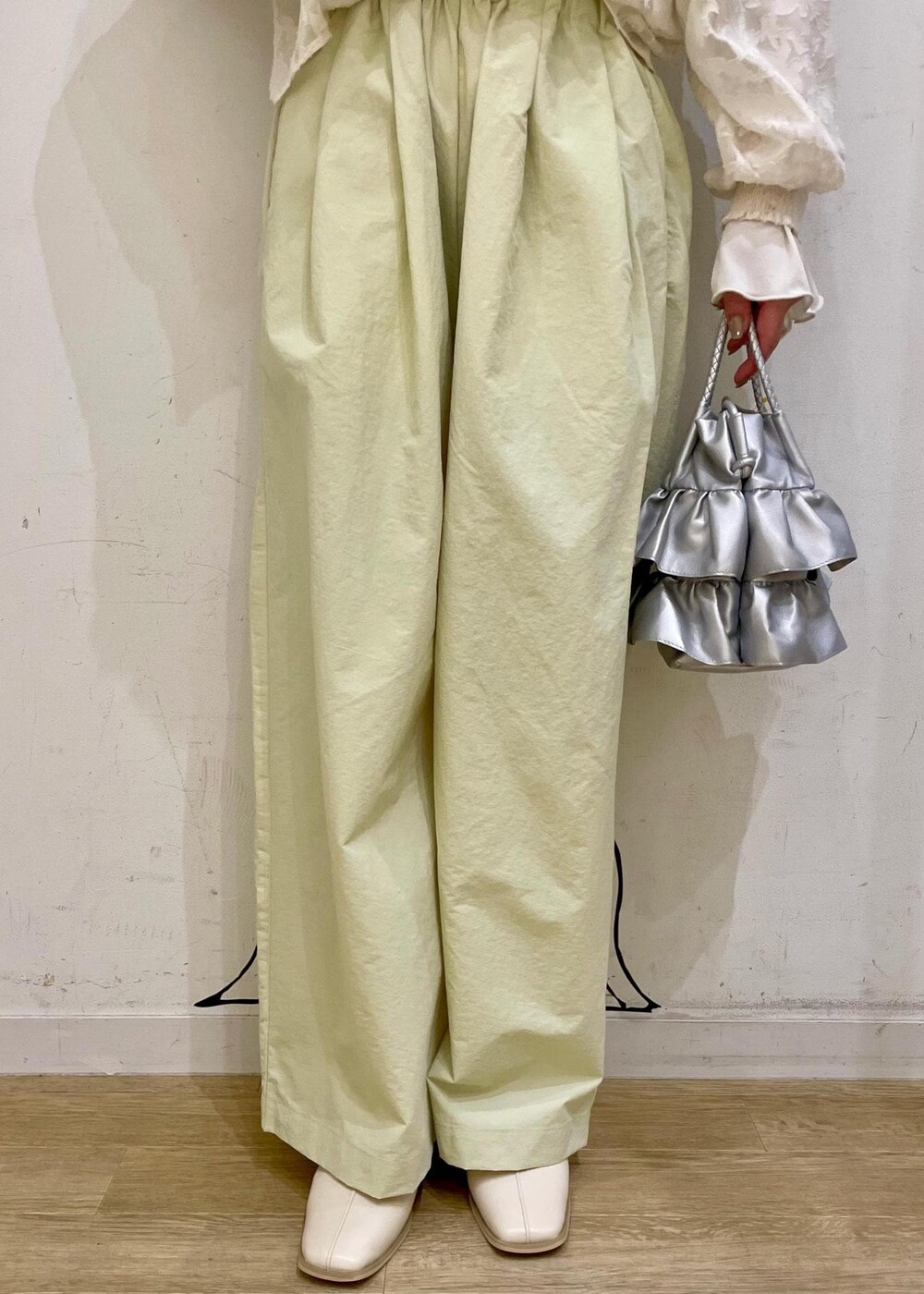 シルバー系のショルダーバッグ、ホワイト系のパンプス、ブルー系のデニムジャケットを着用したレディースの春コーディネートの6枚目の写真