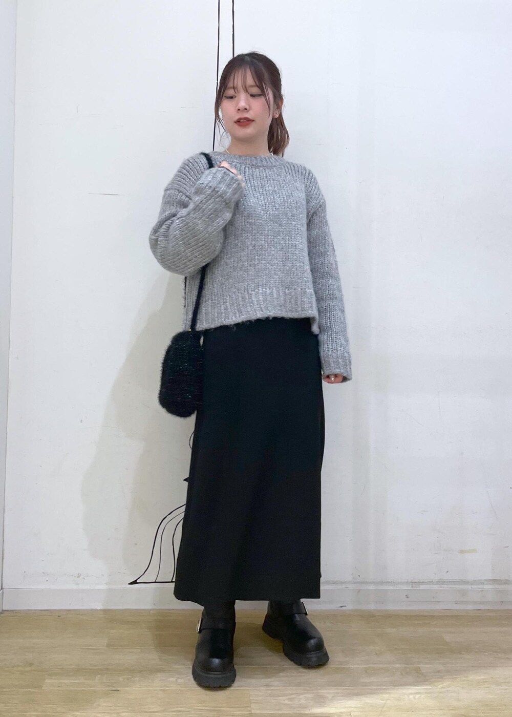 ブラック系のワンピース、ブラック系のショルダーバッグ、グレー系のニット/セーターを着用したレディースの冬コーディネートの4枚目の写真