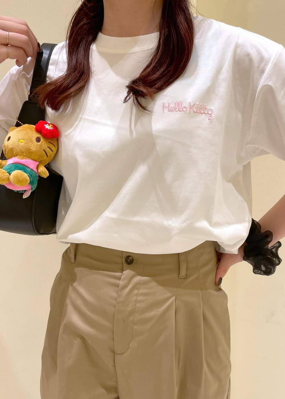 ベージュ系のチノパンツ、ブラウン系のサンダル、ブラック系のハンドバッグを着用したレディースの夏コーディネートの5枚目の写真