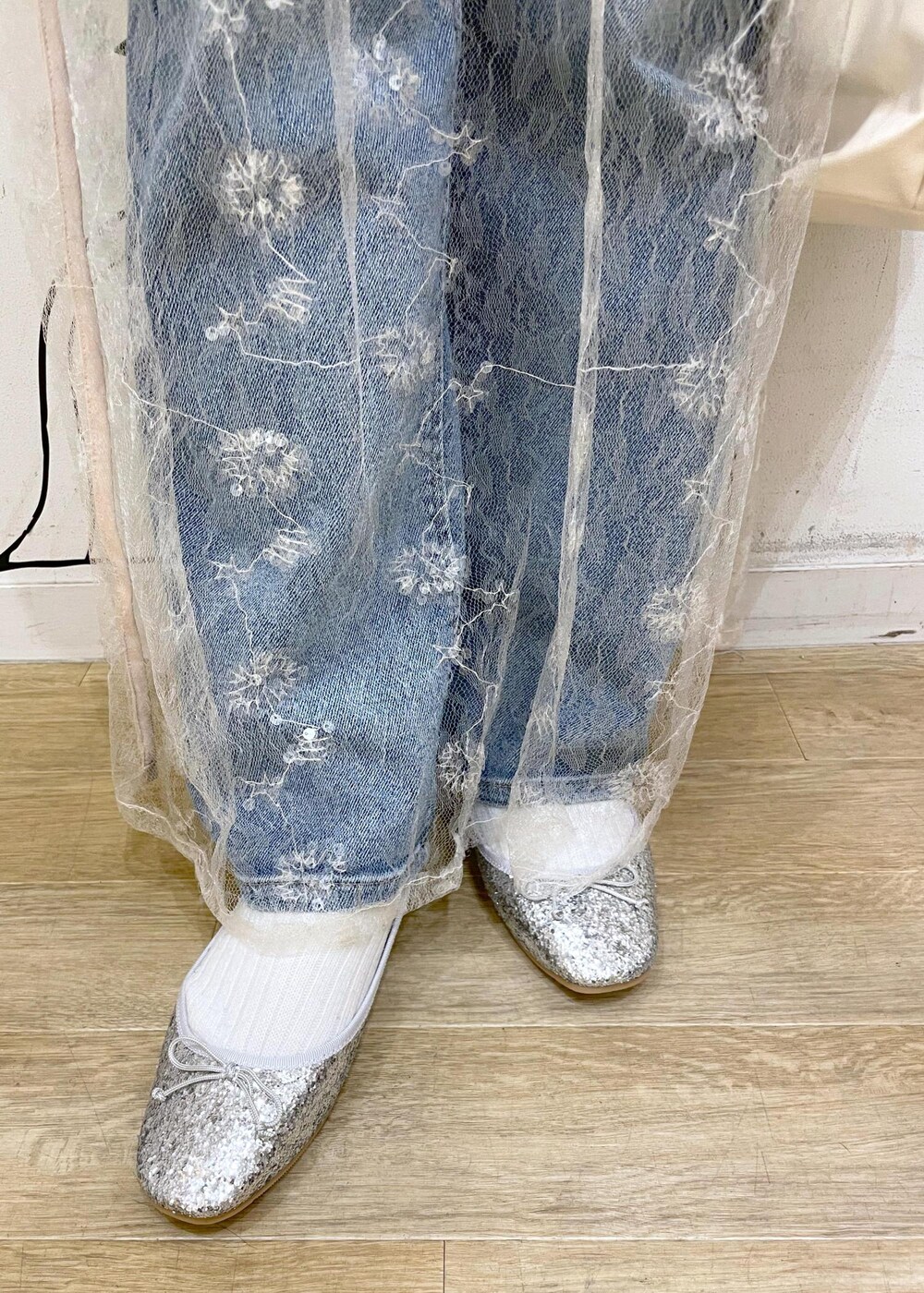 ホワイト系のスカート、シルバー系のバレエシューズ、ブルー系のデニムパンツを着用したレディースの冬コーディネートの8枚目の写真