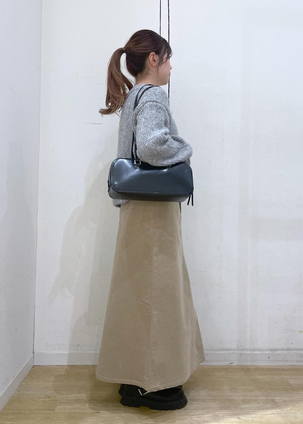 ホワイト系のTシャツ/カットソー、ブラック系のボストンバッグ、ベージュ系のスカートを着用したレディースの冬コーディネートの3枚目の写真