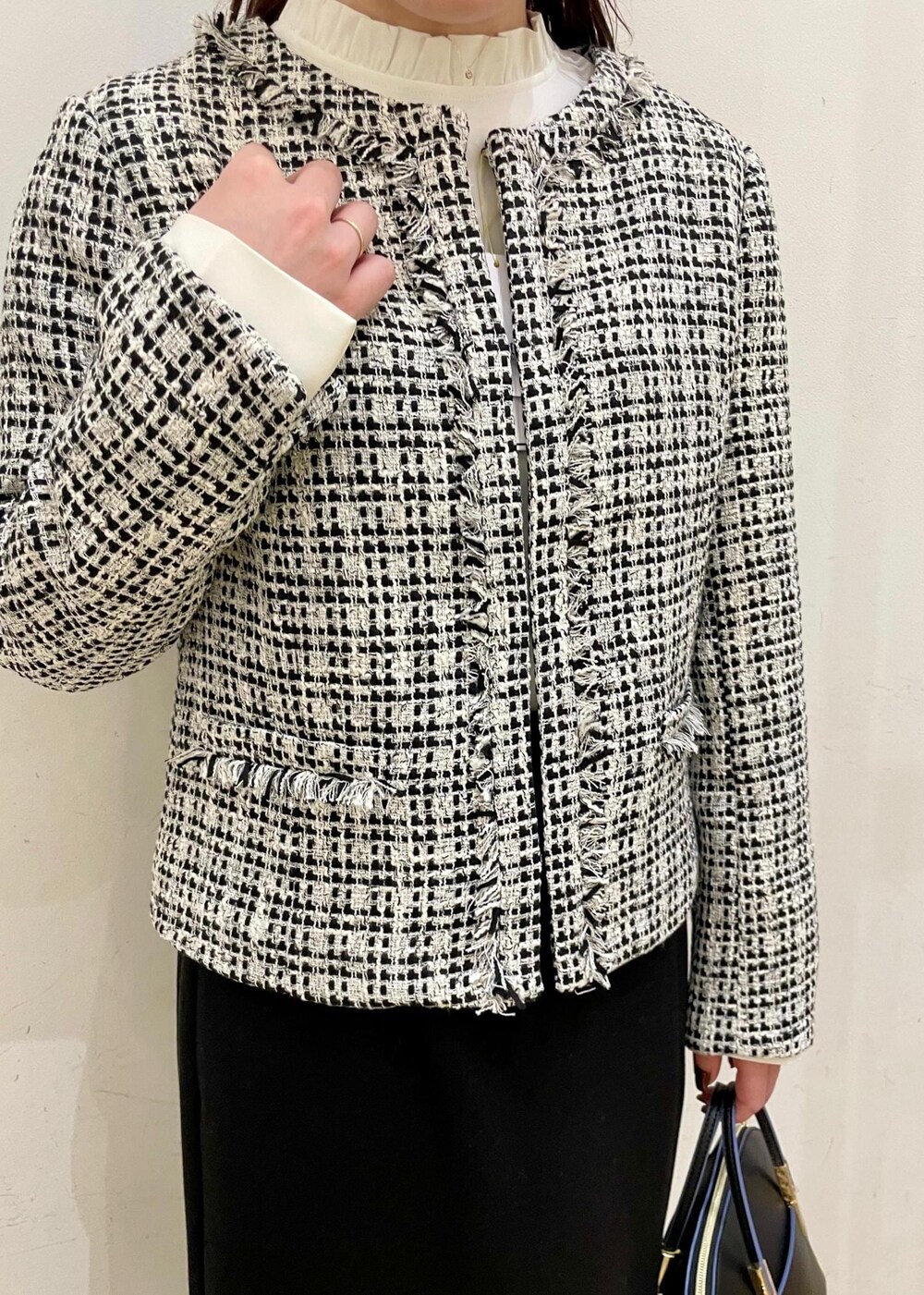 ブラック系のスカート、ホワイト系のシャツ/ブラウス、ブラック系のショルダーバッグを着用したレディースの冬コーディネートの4枚目の写真