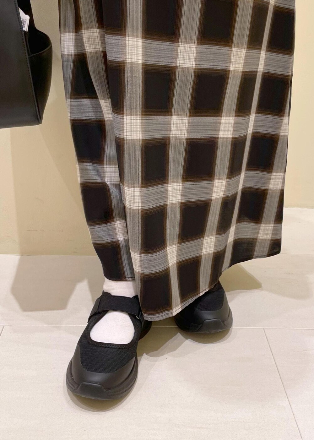 ブラック系のハンドバッグ、ブラック系のスニーカー、ホワイト系のキャミソールを着用したレディースの夏コーディネートの9枚目の写真