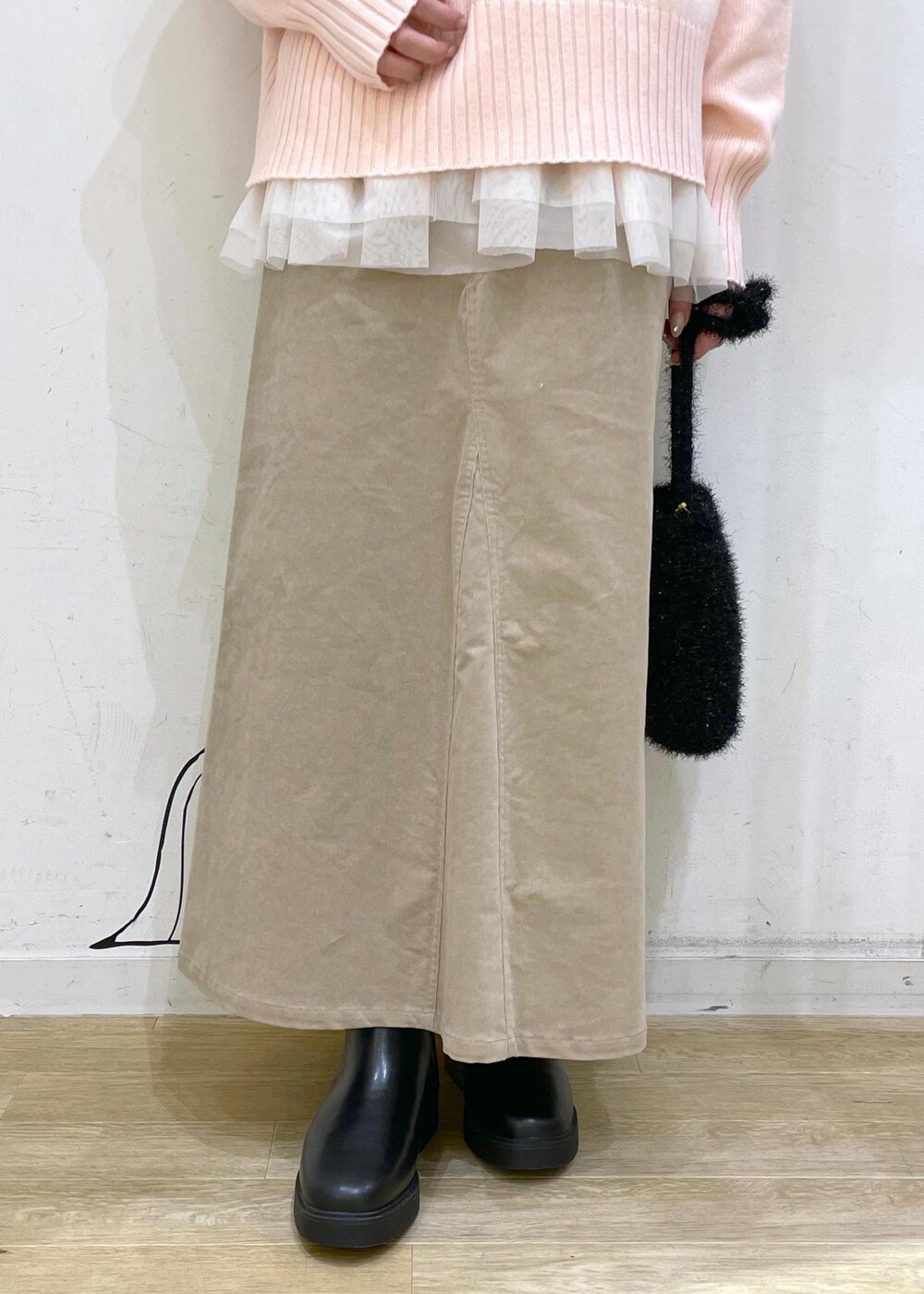 ピンク系のニット/セーター、ブラック系のブーツ、ブラック系のショルダーバッグを着用したレディースの冬コーディネートの5枚目の写真