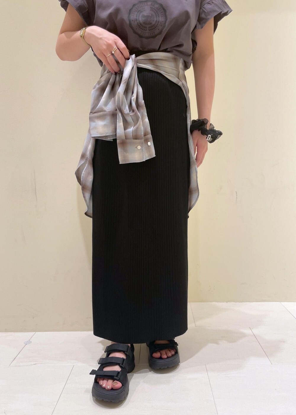 ブラック系のスカート、ブラック系のサンダル、グレー系のTシャツ/カットソーを着用したレディースの夏コーディネートの6枚目の写真