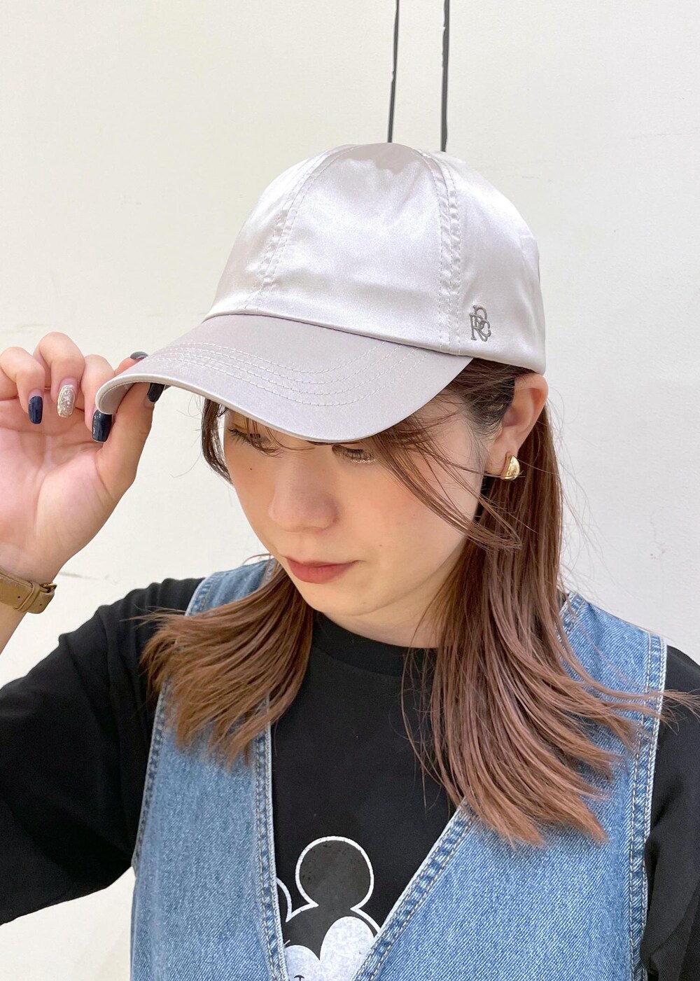 ホワイト系のスニーカー、ブラック系のハンドバッグ、ブルー系のジャンパースカートを着用したレディースの夏コーディネートの8枚目の写真