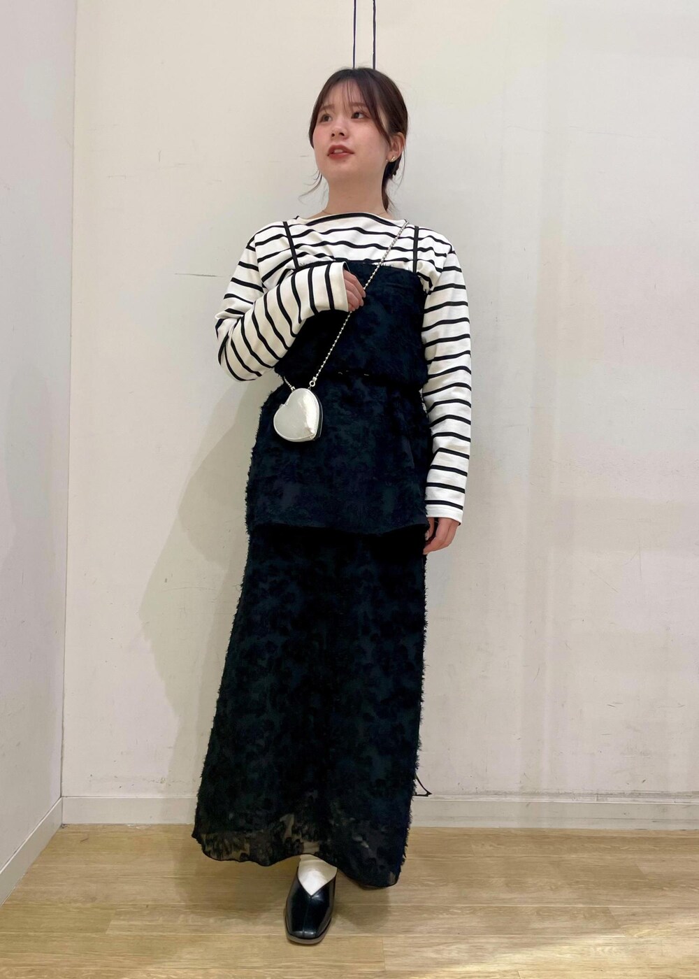 ホワイト系のTシャツ/カットソー、ブラック系のパンプス、ブラック系のスカートを着用したレディースの春コーディネートの8枚目の写真
