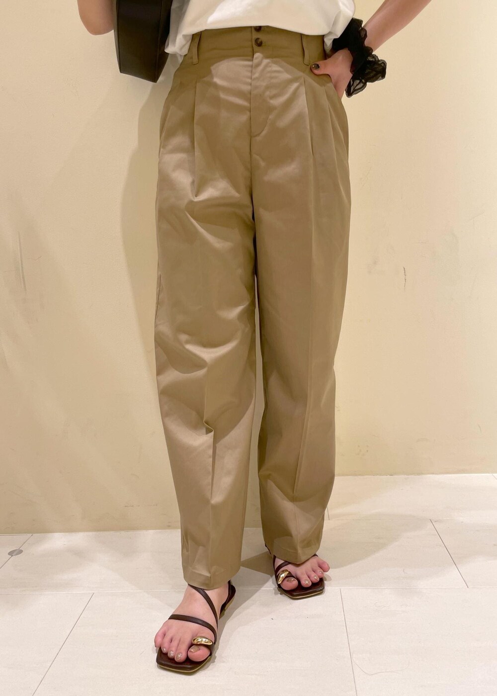 ベージュ系のチノパンツ、ブラウン系のサンダル、ブラック系のハンドバッグを着用したレディースの夏コーディネートの7枚目の写真