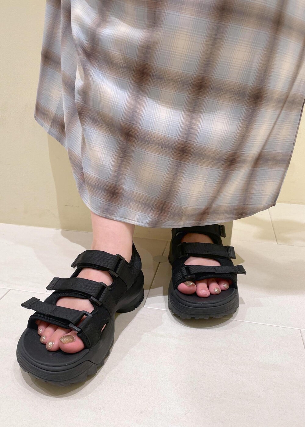 ブラック系のサンダル、ブルー系のワンピース、ホワイト系のTシャツ/カットソーを着用したレディースの夏コーディネートの8枚目の写真