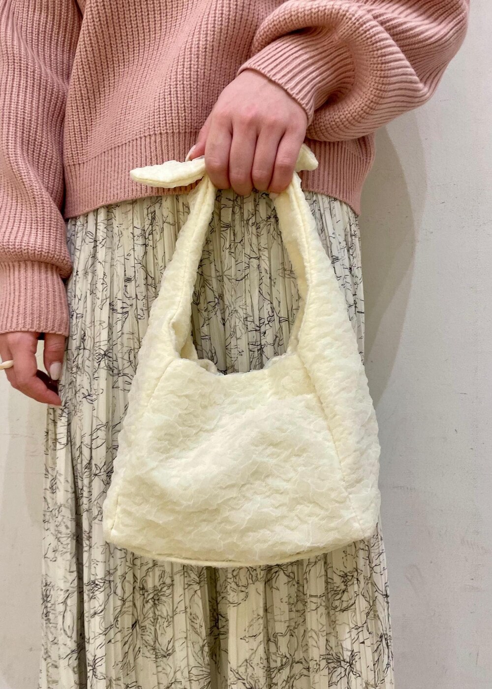 ホワイト系のスカート、ブラウン系のローファー、ホワイト系のショルダーバッグを着用したレディースの冬コーディネートの6枚目の写真