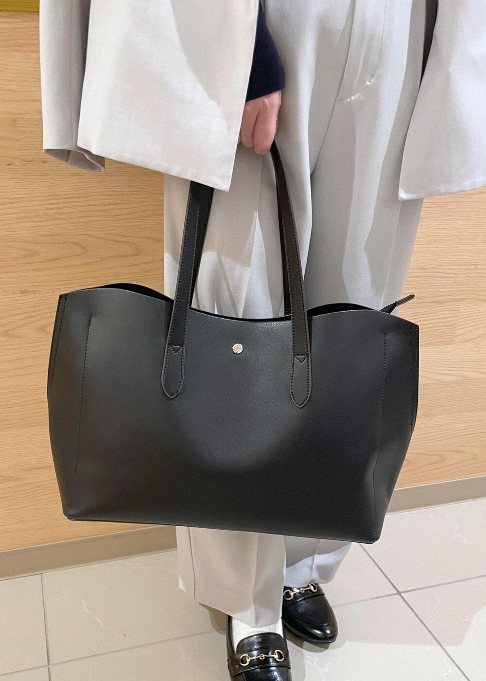 ブラック系のトートバッグ、ブラック系のパンプス、ブルー系のカーディガン/ボレロを着用したレディースの春コーディネートの8枚目の写真