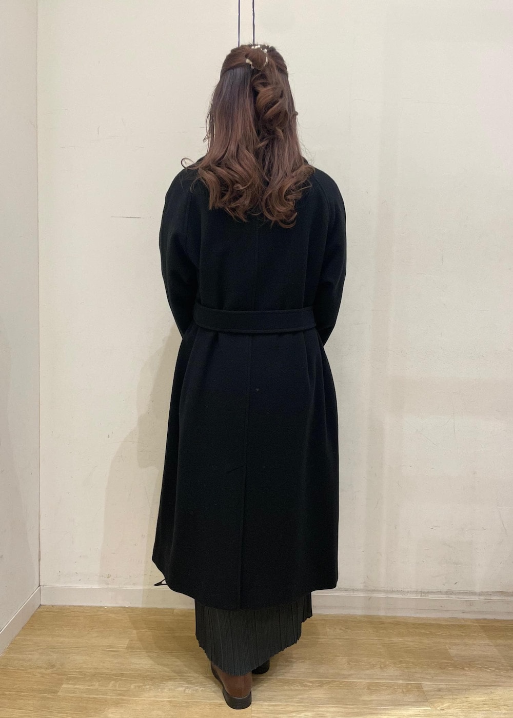 ブラウン系のローファー、グレー系のスカート、ブラック系のチェスターコートを着用したレディースの冬コーディネートの2枚目の写真