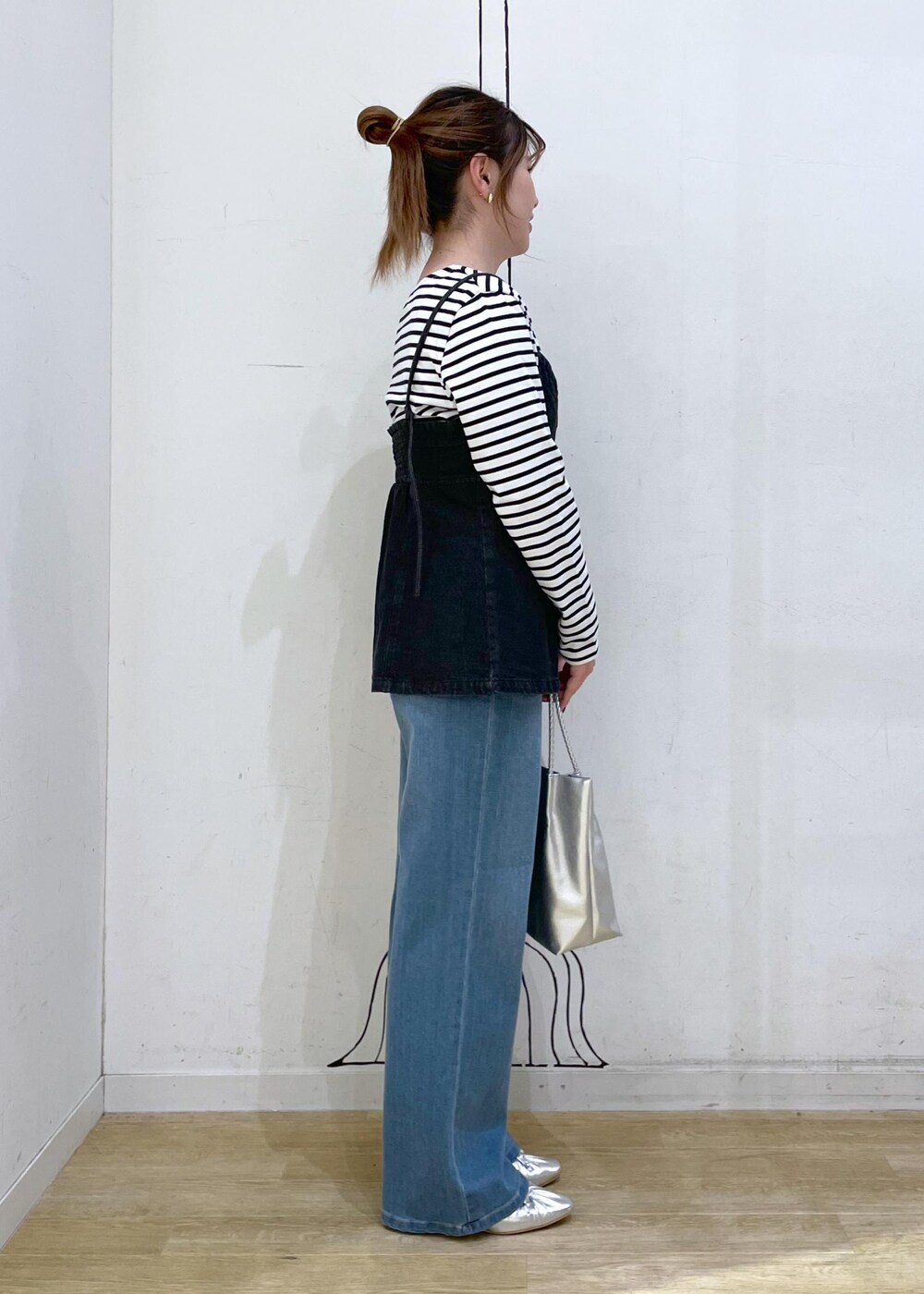 シルバー系のパンプス、ホワイト系のTシャツ/カットソー、ブラック系のベストを着用したレディースの秋コーディネートの3枚目の写真