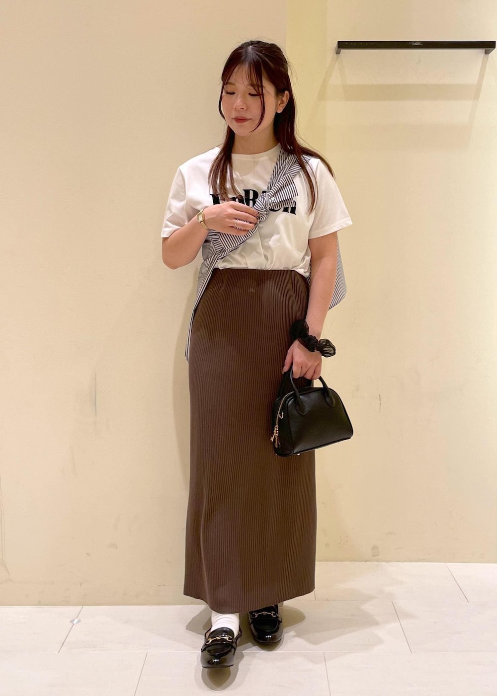 ブルー系のシャツ/ブラウス、ホワイト系のTシャツ/カットソー、ブラック系のローファーを着用したレディースの秋コーディネートの4枚目の写真