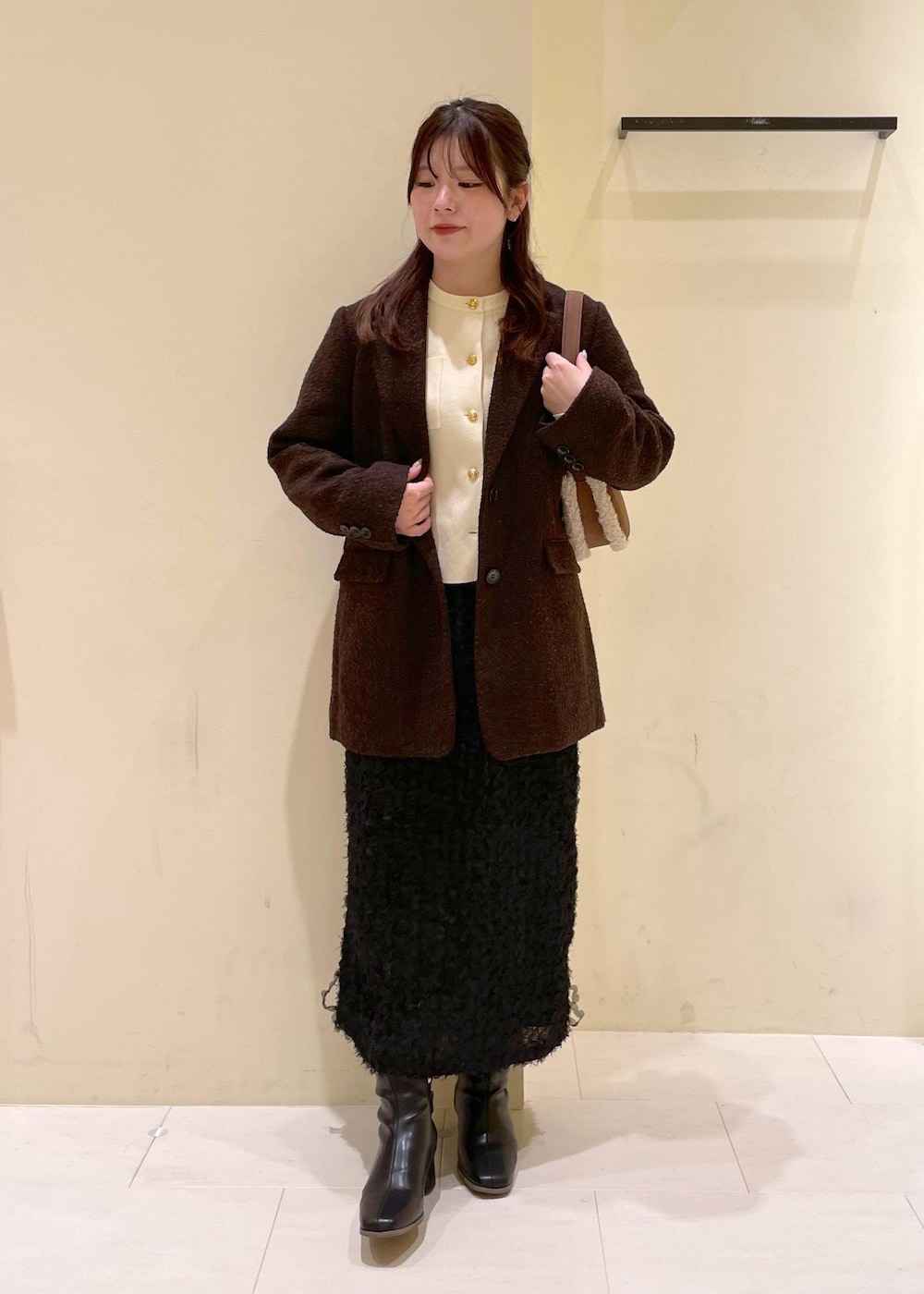 ホワイト系のカーディガン/ボレロ、ブラック系のブーツ、ブラウン系のテーラードジャケットを着用したレディースの秋コーディネートの9枚目の写真