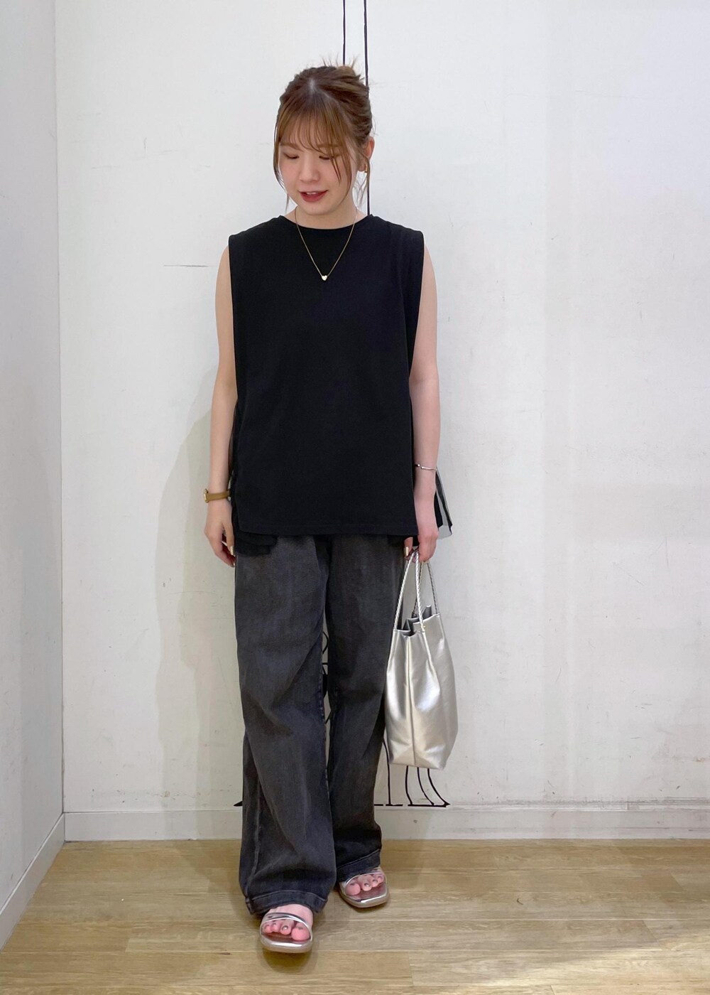 ブラック系のTシャツ/カットソー、シルバー系のサンダル、ブラック系のデニムパンツを着用したレディースの夏コーディネートの4枚目の写真