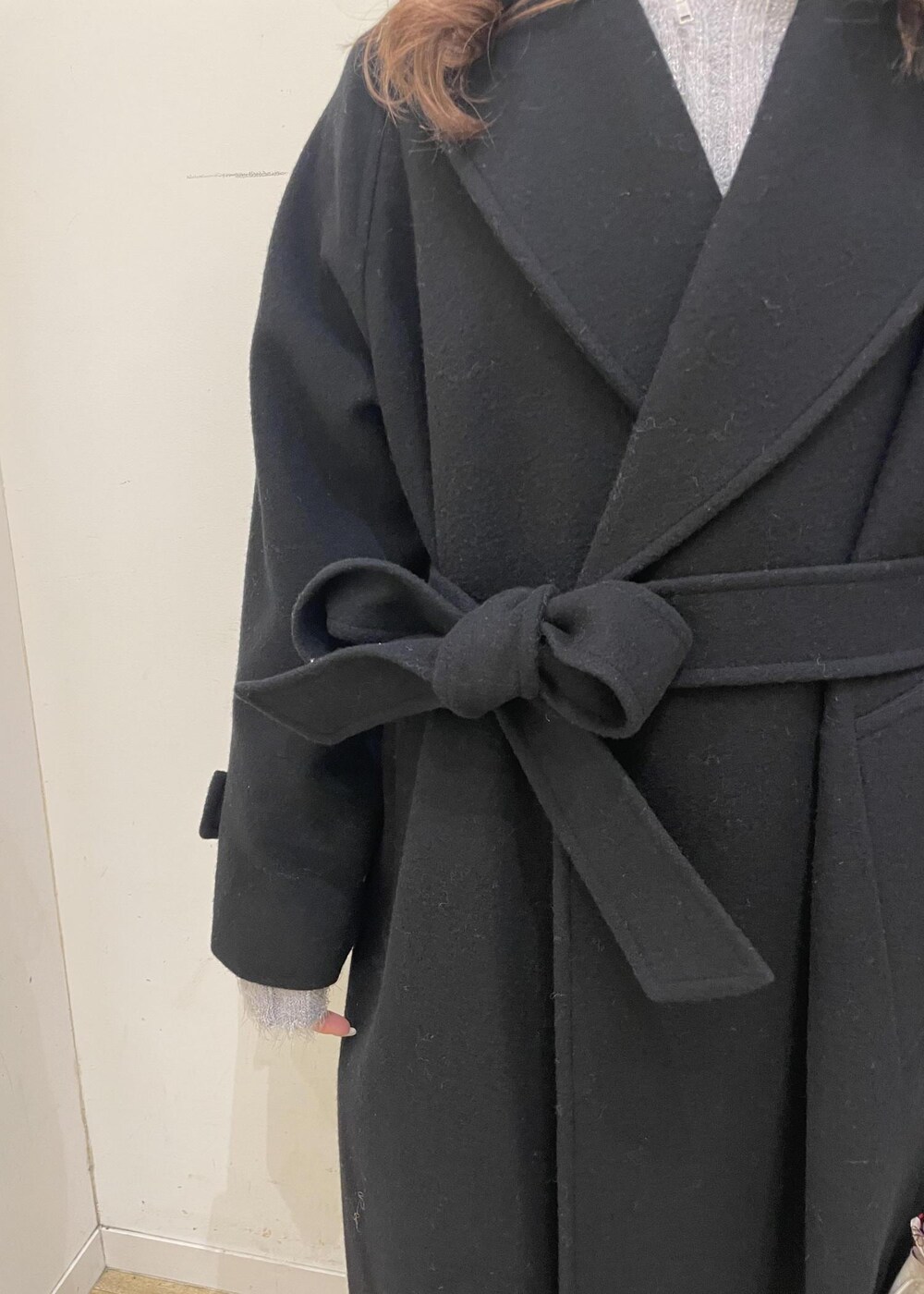 ブラウン系のローファー、グレー系のスカート、ブラック系のチェスターコートを着用したレディースの冬コーディネートの4枚目の写真