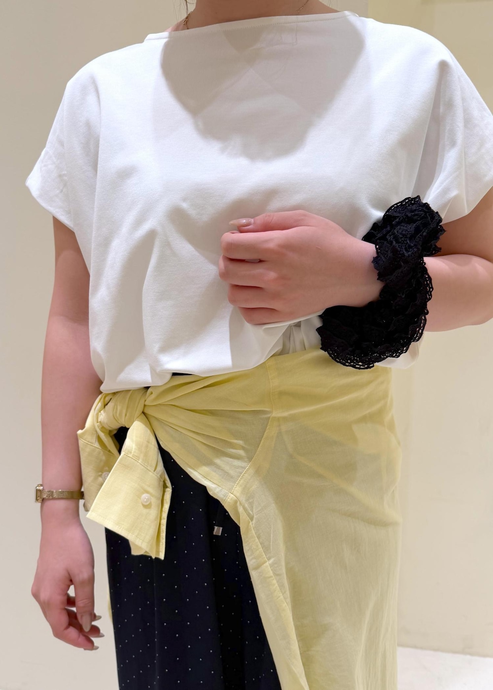ブラック系のショルダーバッグ、イエロー系のシャツ/ブラウス、ホワイト系のTシャツ/カットソーを着用したレディースの夏コーディネートの6枚目の写真