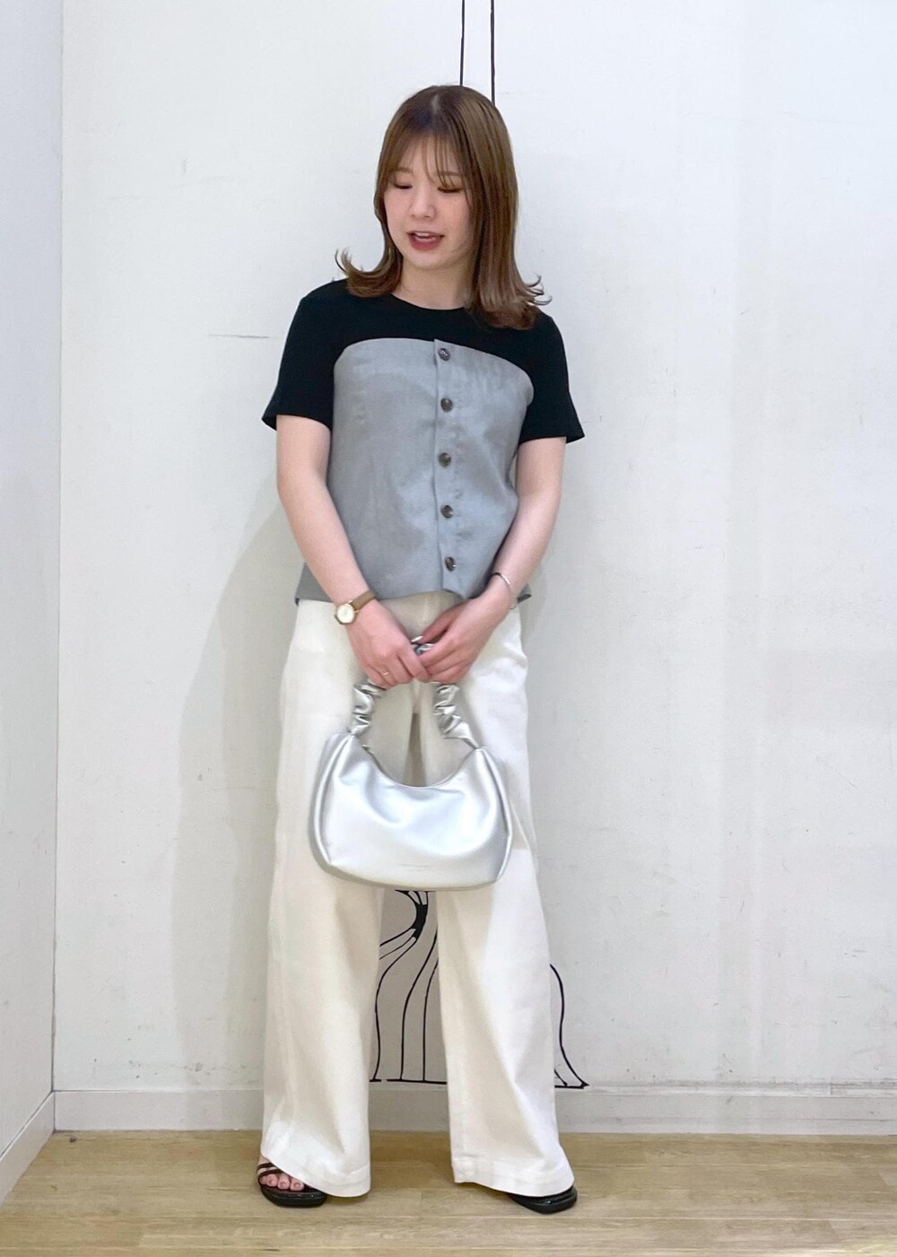 ブラック系のTシャツ/カットソー、ブラック系のサンダル、ホワイト系のデニムパンツを着用したレディースの春コーディネートの8枚目の写真
