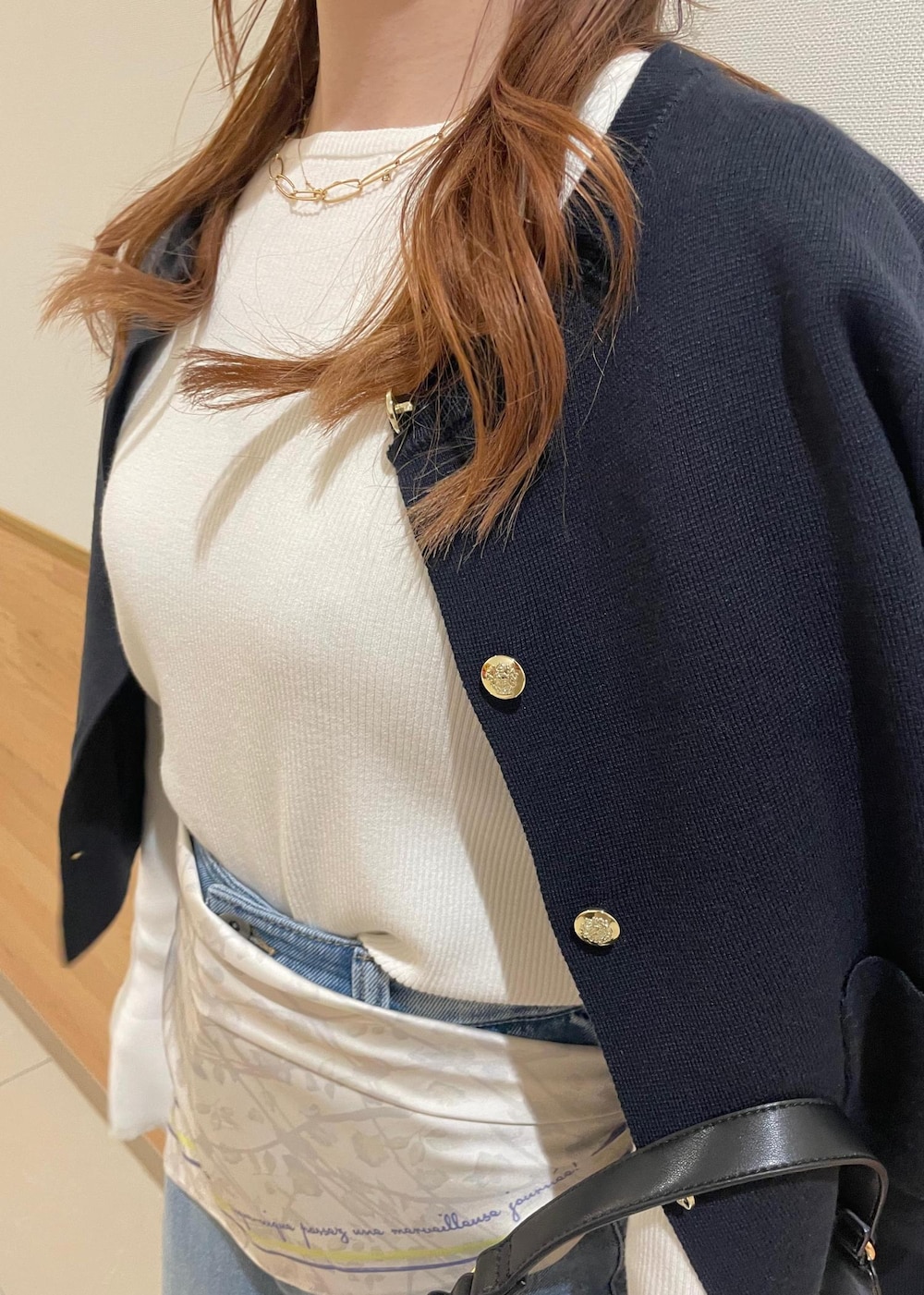 ブルー系のカーディガン/ボレロ、ホワイト系のニット/セーター、ブラック系のハンドバッグを着用したレディースの春コーディネートの5枚目の写真