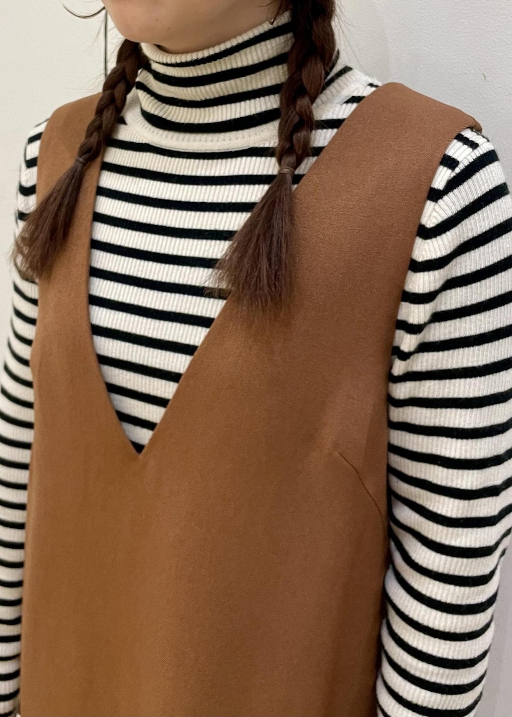 ホワイト系のニット/セーター、ブラウン系のジャンパースカート、ブラック系のローファーを着用したレディースの冬コーディネートの5枚目の写真