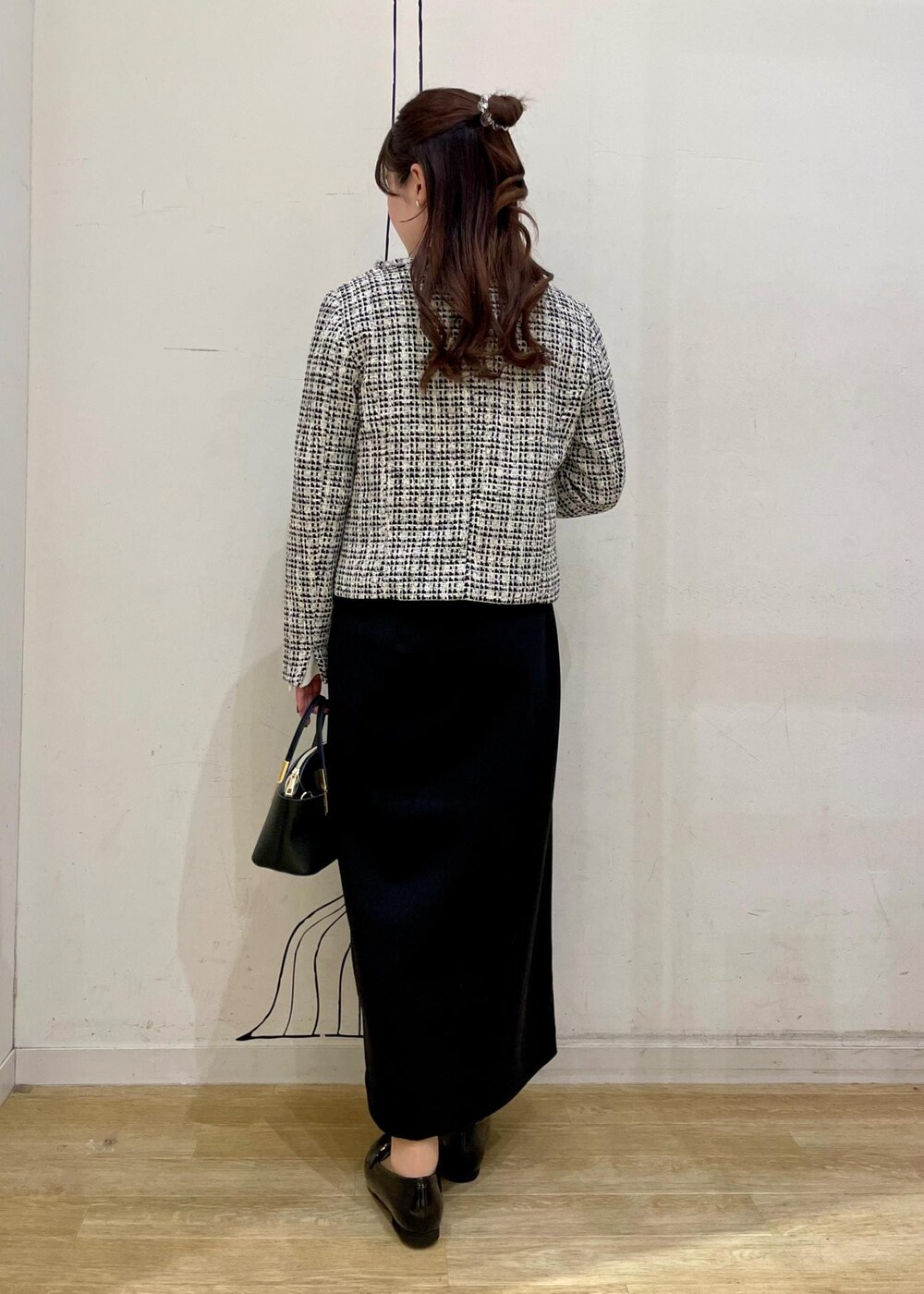 ブラック系のスカート、ホワイト系のシャツ/ブラウス、ブラック系のショルダーバッグを着用したレディースの冬コーディネートの2枚目の写真