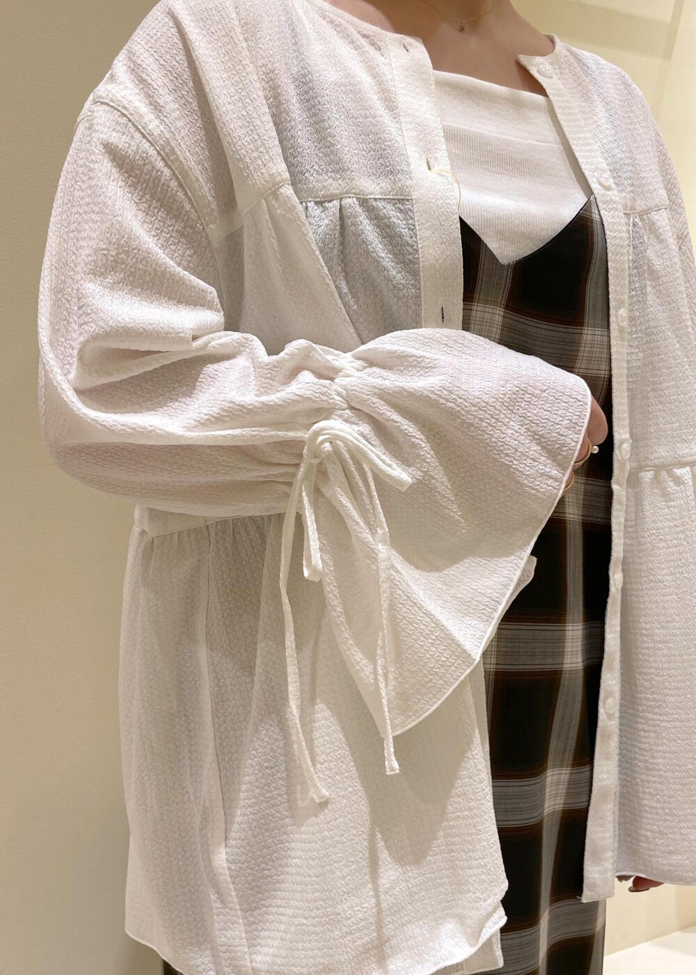 ブラック系のハンドバッグ、ブラック系のスニーカー、ホワイト系のキャミソールを着用したレディースの夏コーディネートの6枚目の写真